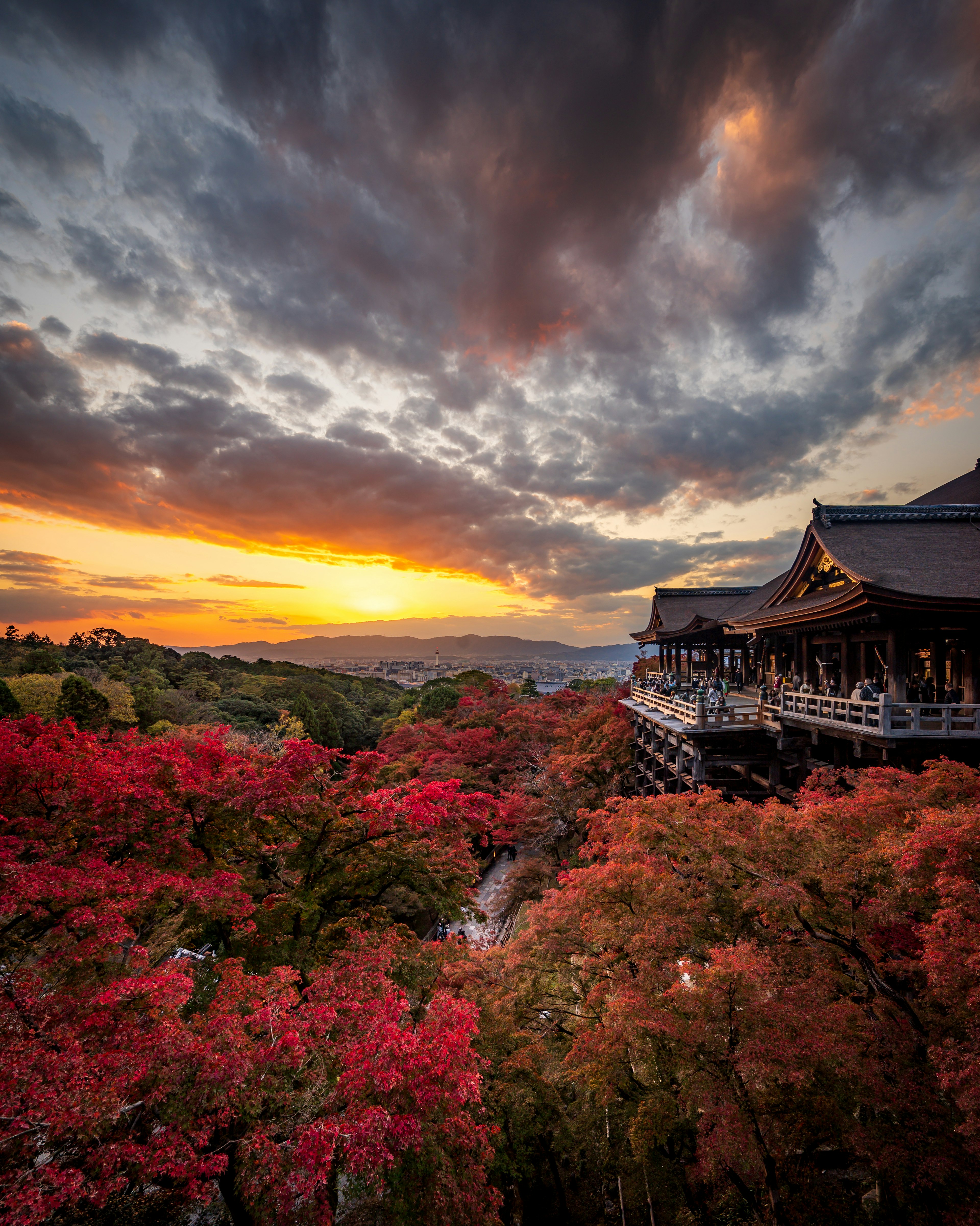 Vista panoramica del Kiyomizu-dera con foglie autunnali vibranti sotto un tramonto colorato