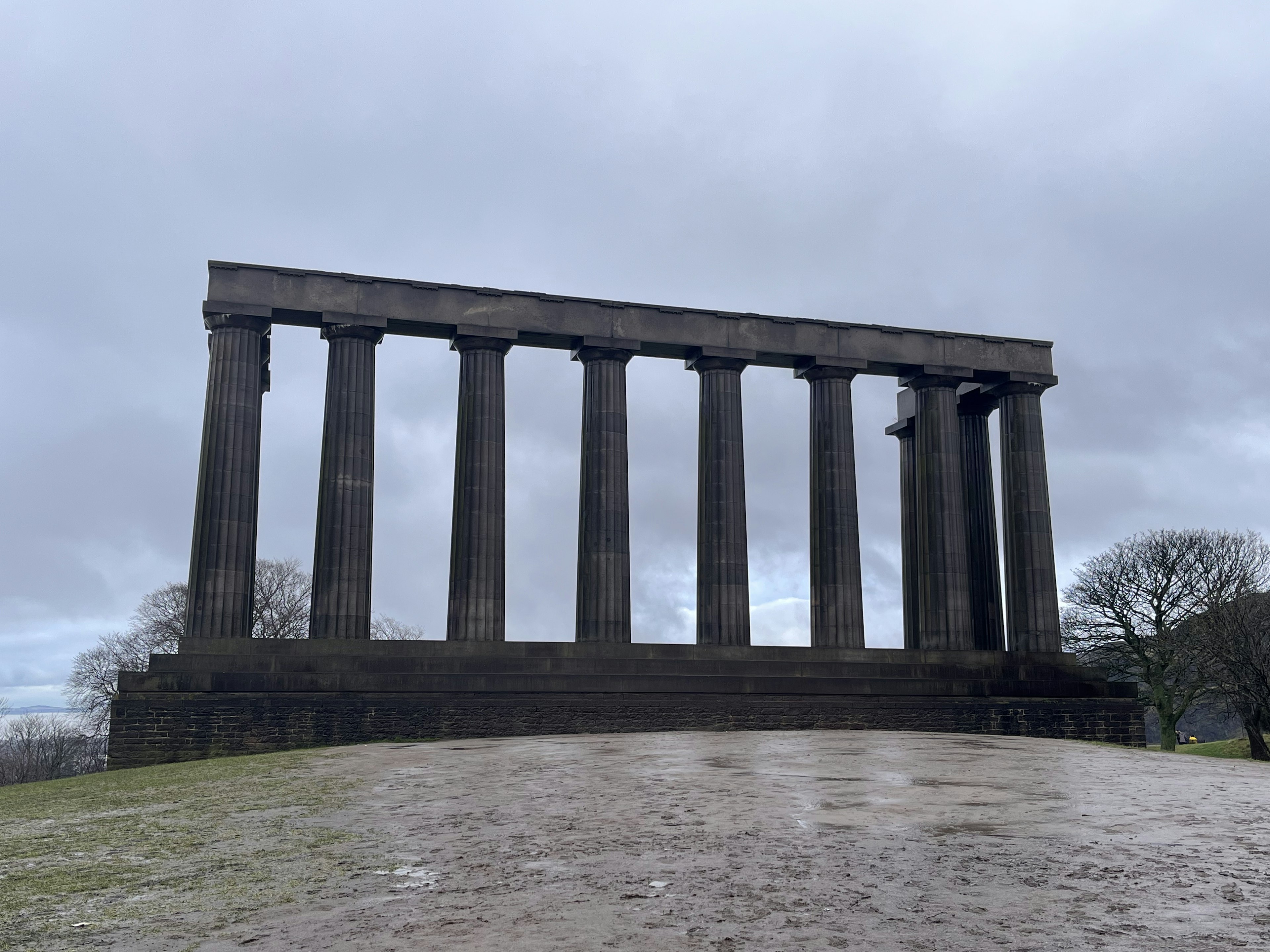 古代風の柱が立ち並ぶ風景 雲の多い空の下