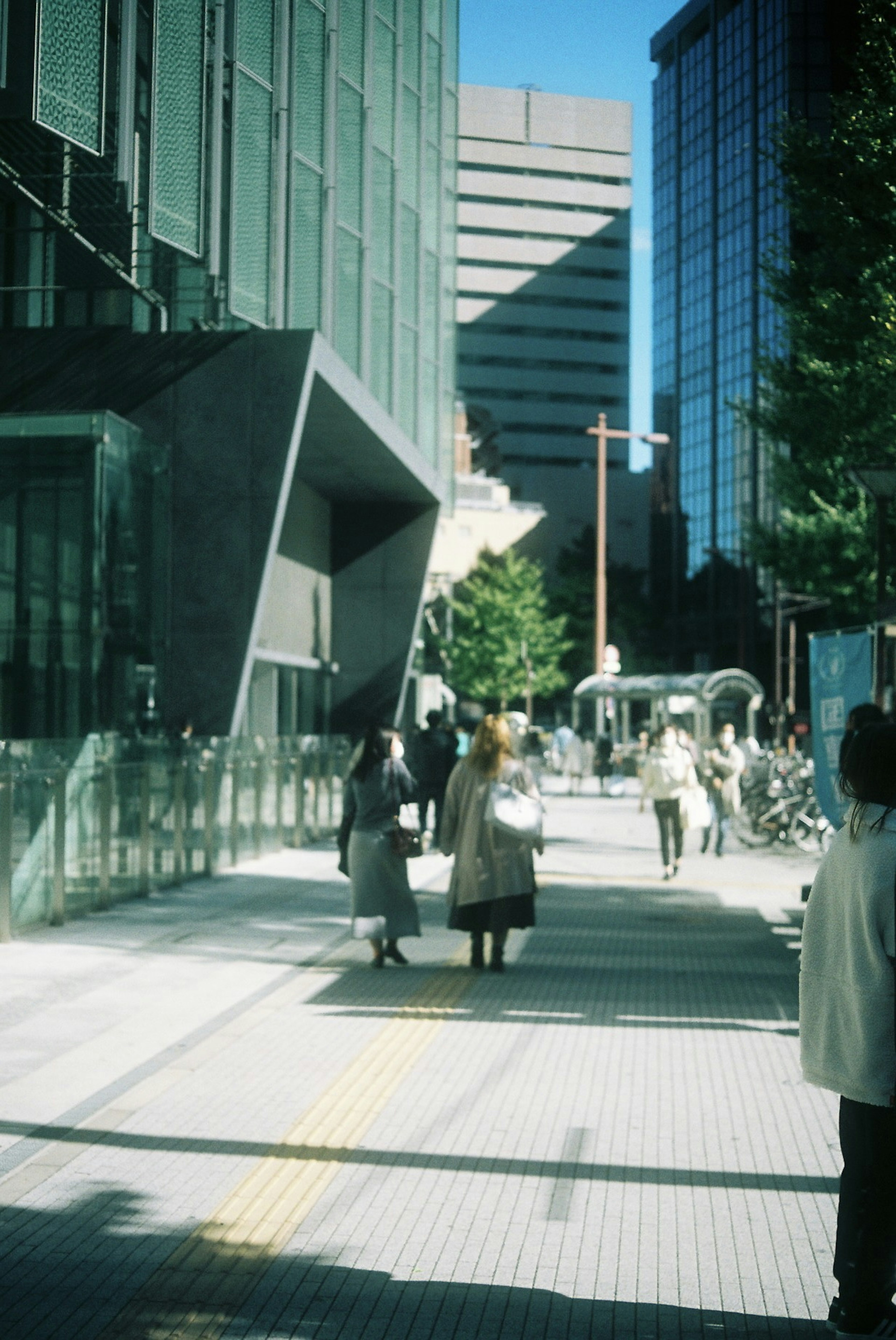 People walking in a modern urban street with tall buildings