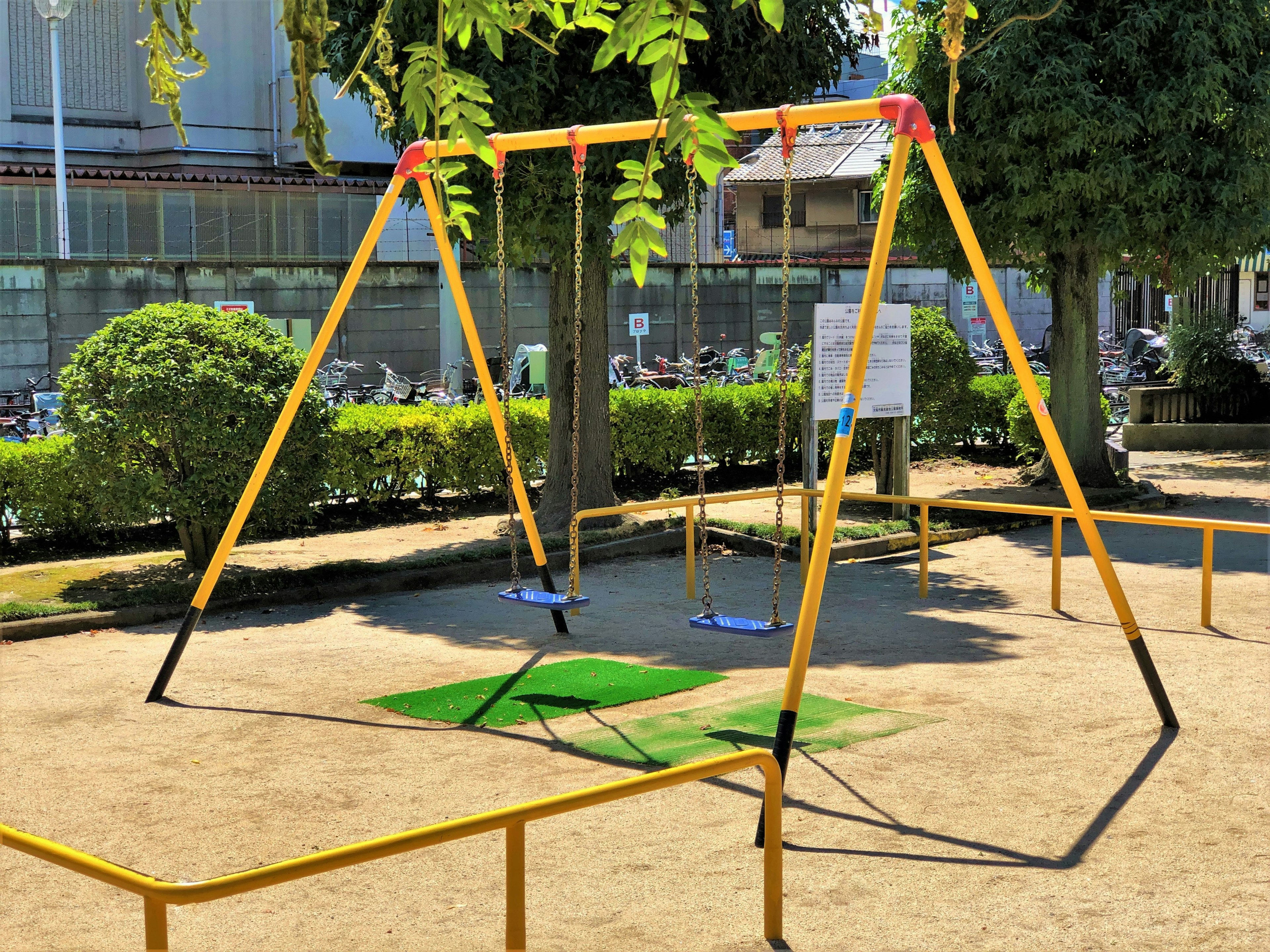 Playground scene featuring yellow swings in a park