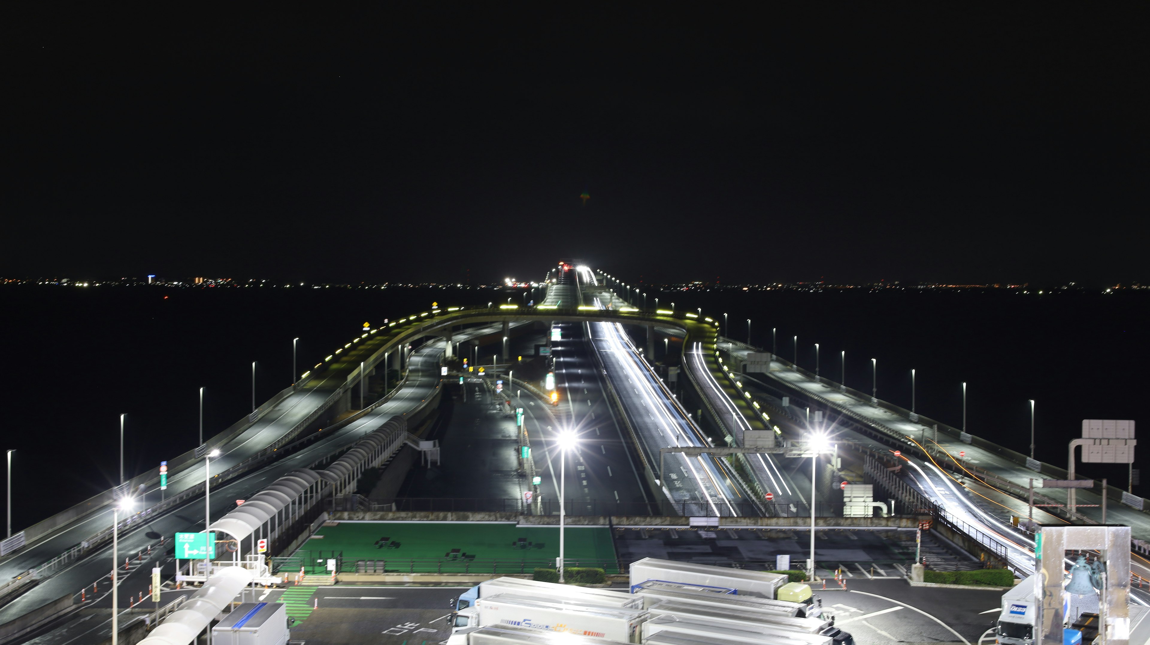 Pemandangan jembatan dan jalan yang diterangi di malam hari