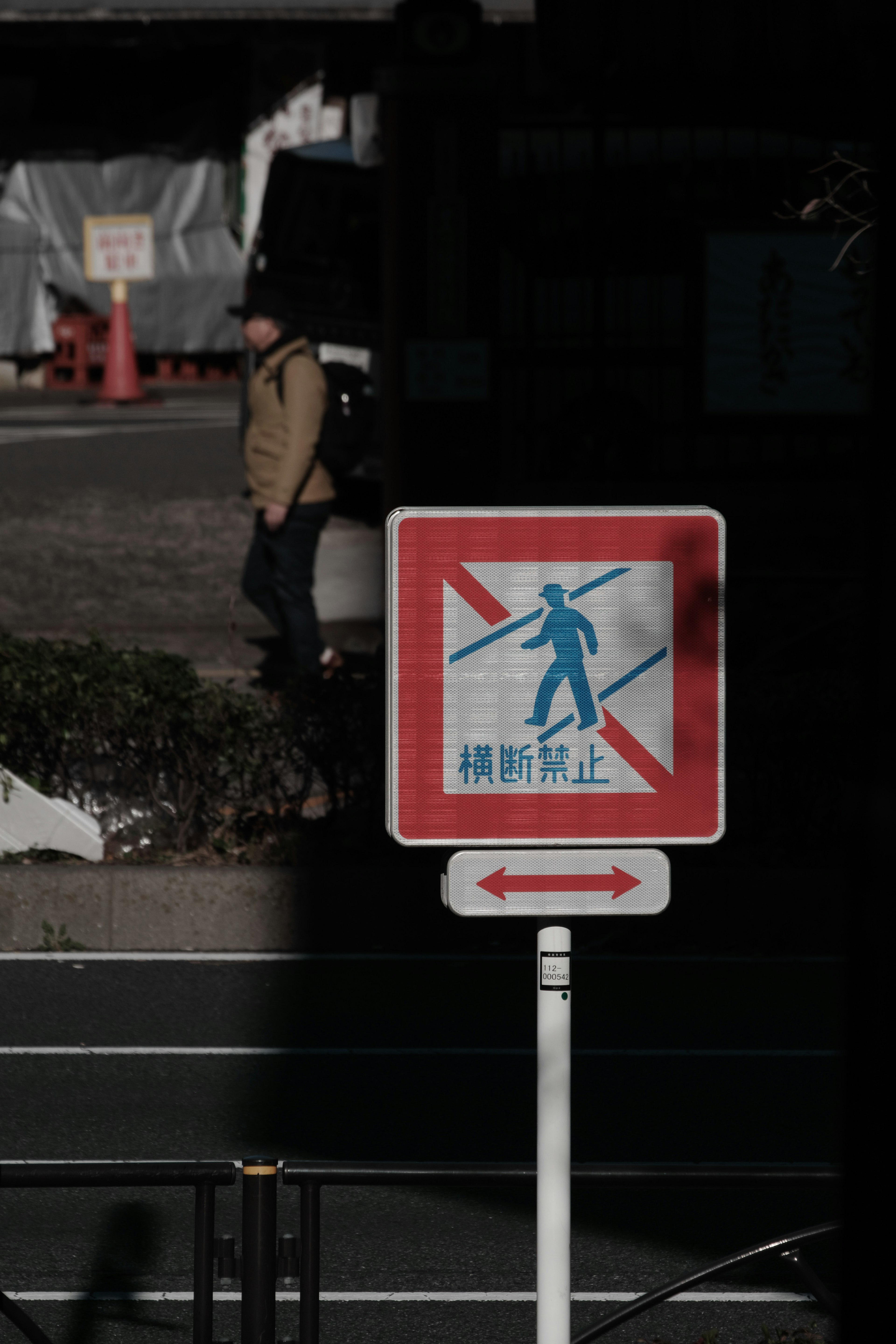 No walking sign with a person walking in the background