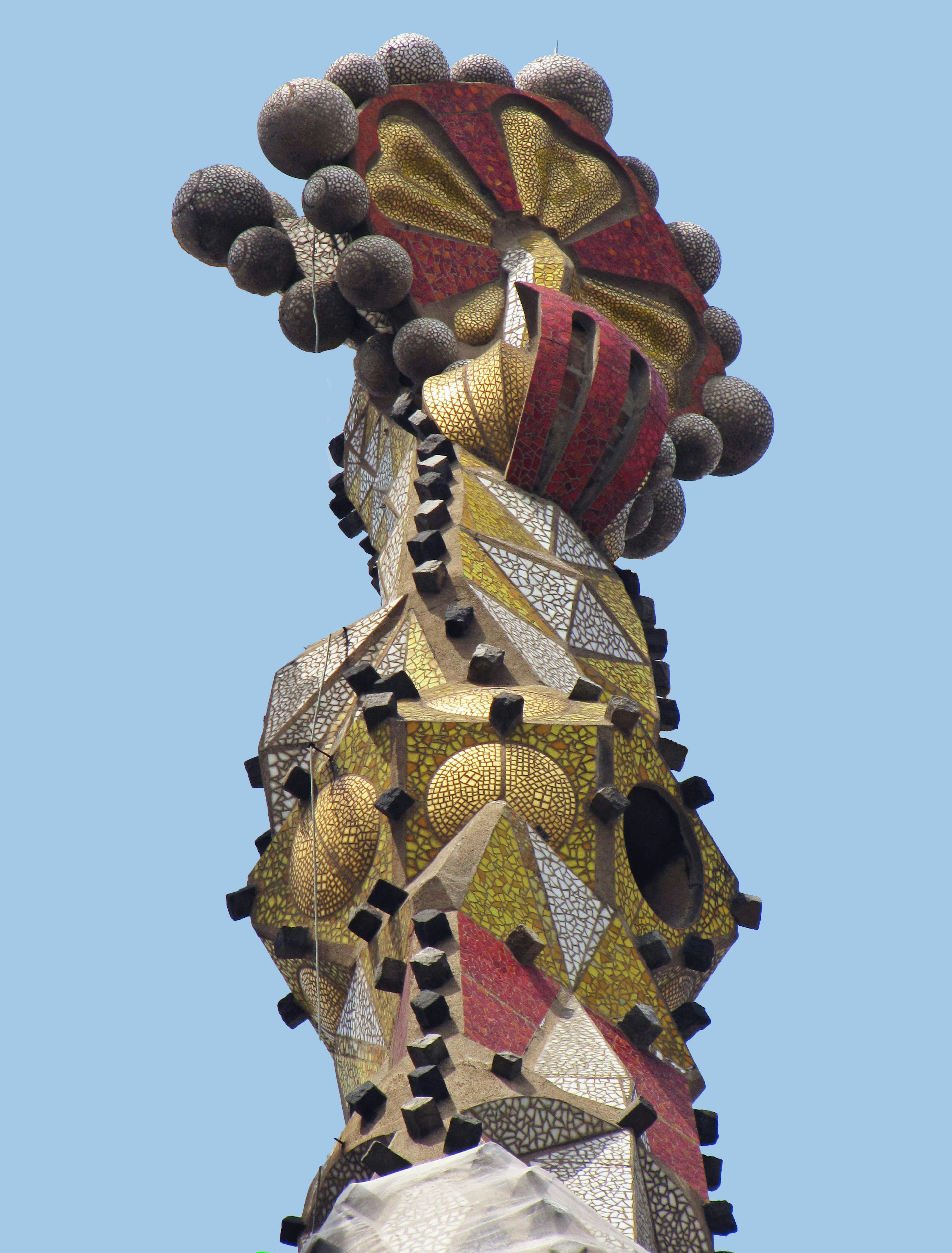 Colorful mosaic sculpture featuring a female form striking decorative hat