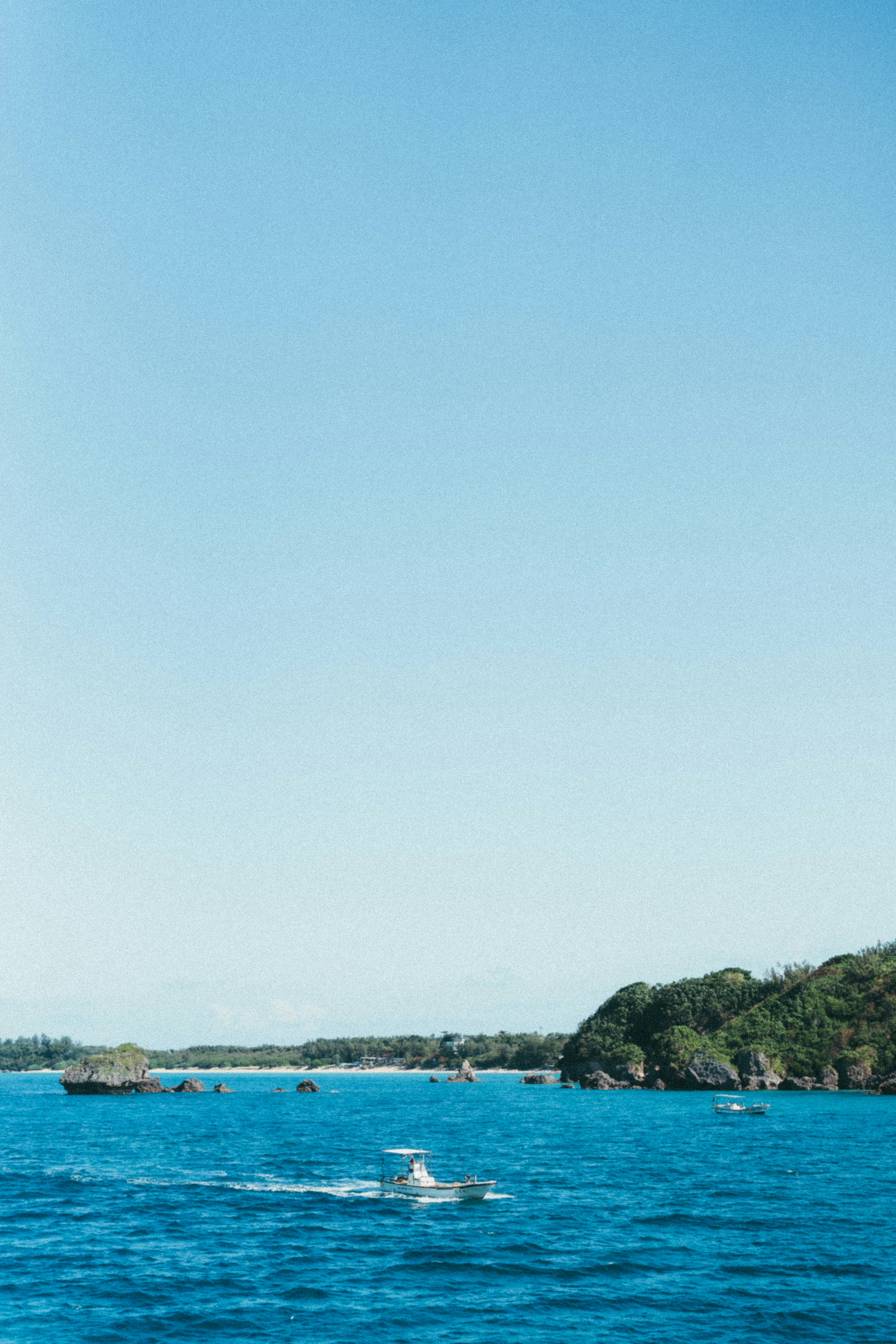 Ein Boot, das auf einem blauen Meer unter einem klaren Himmel fährt