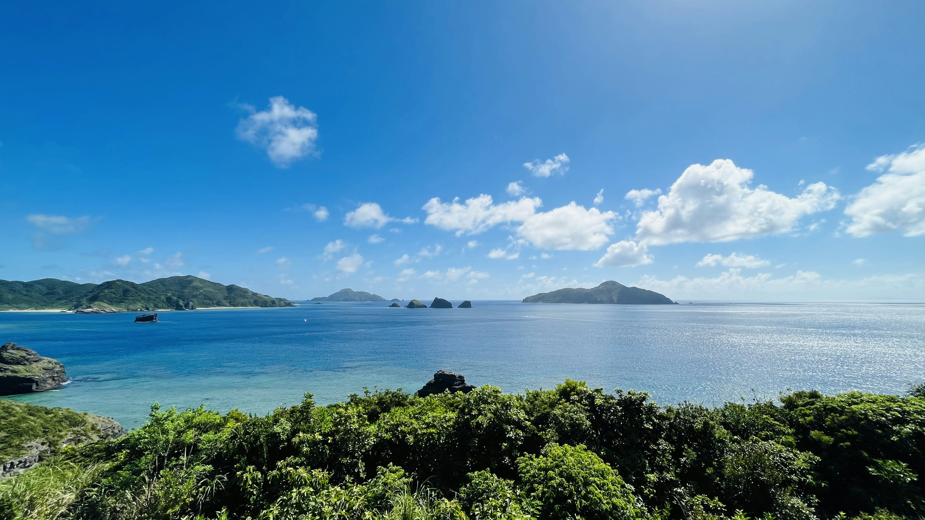 青い海と空の美しい景色 島々と緑の植物が見える