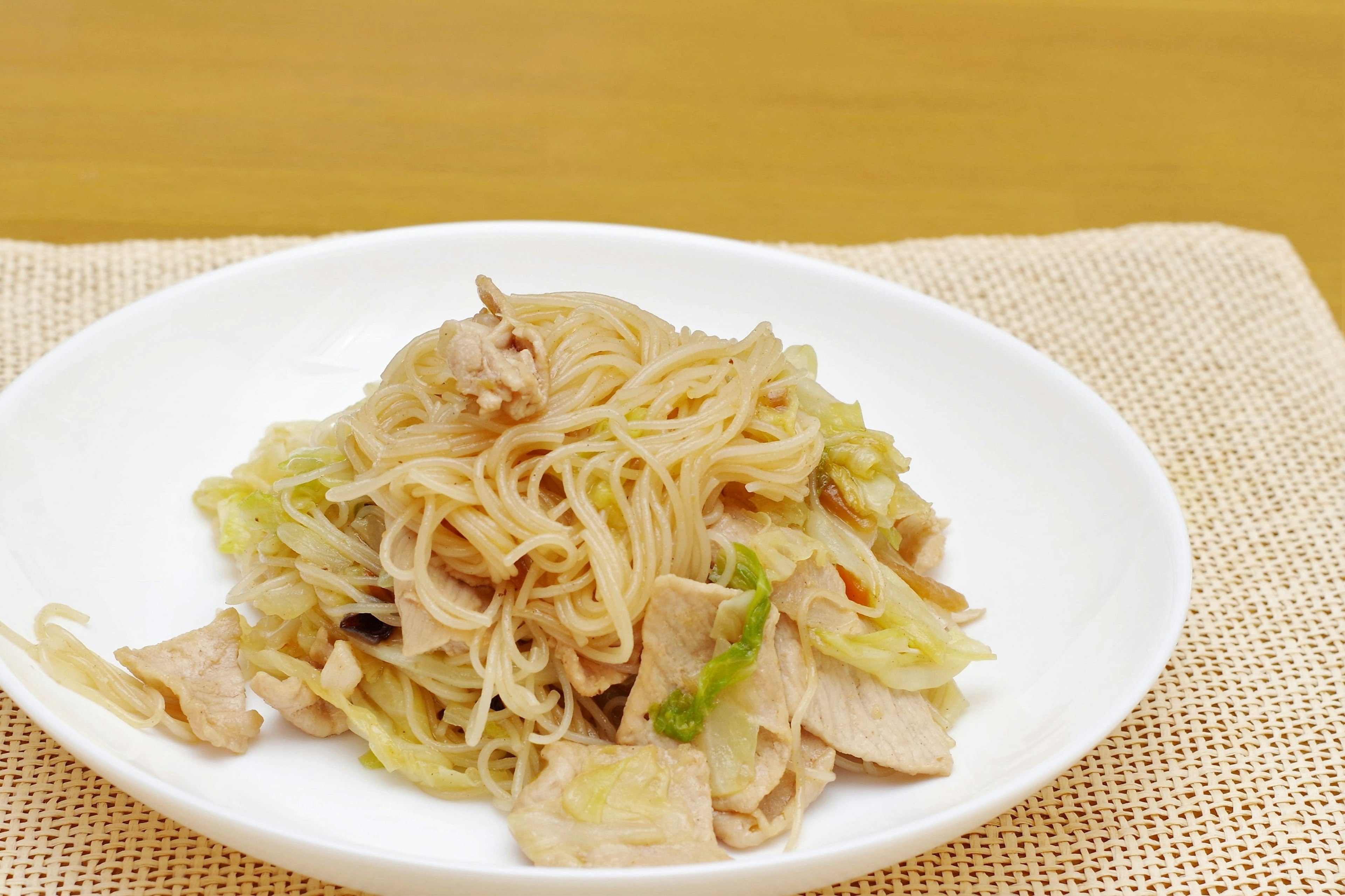 Plate of stir-fried noodles with chicken and cabbage