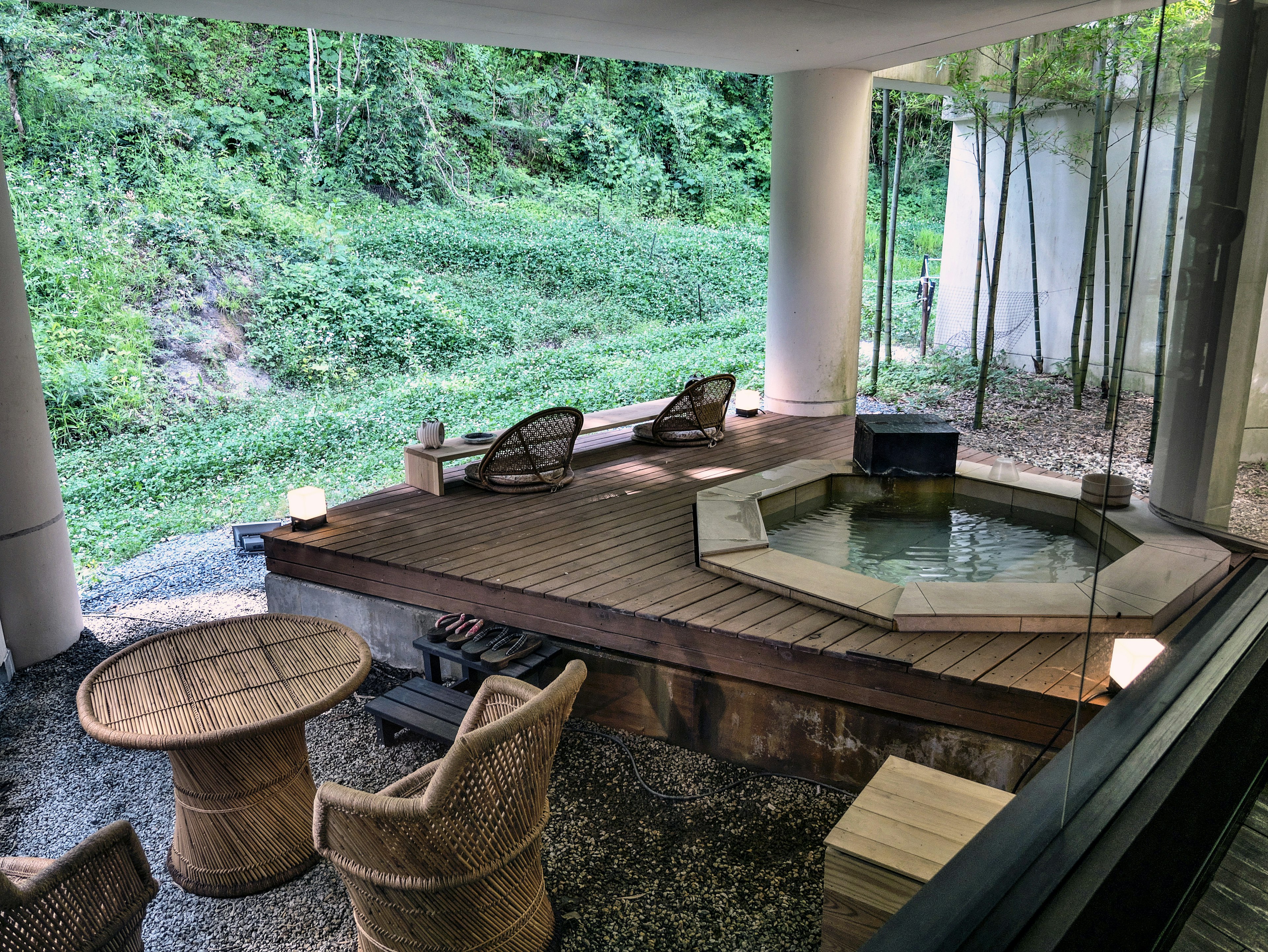 Baño caliente al aire libre rodeado de naturaleza con área de descanso