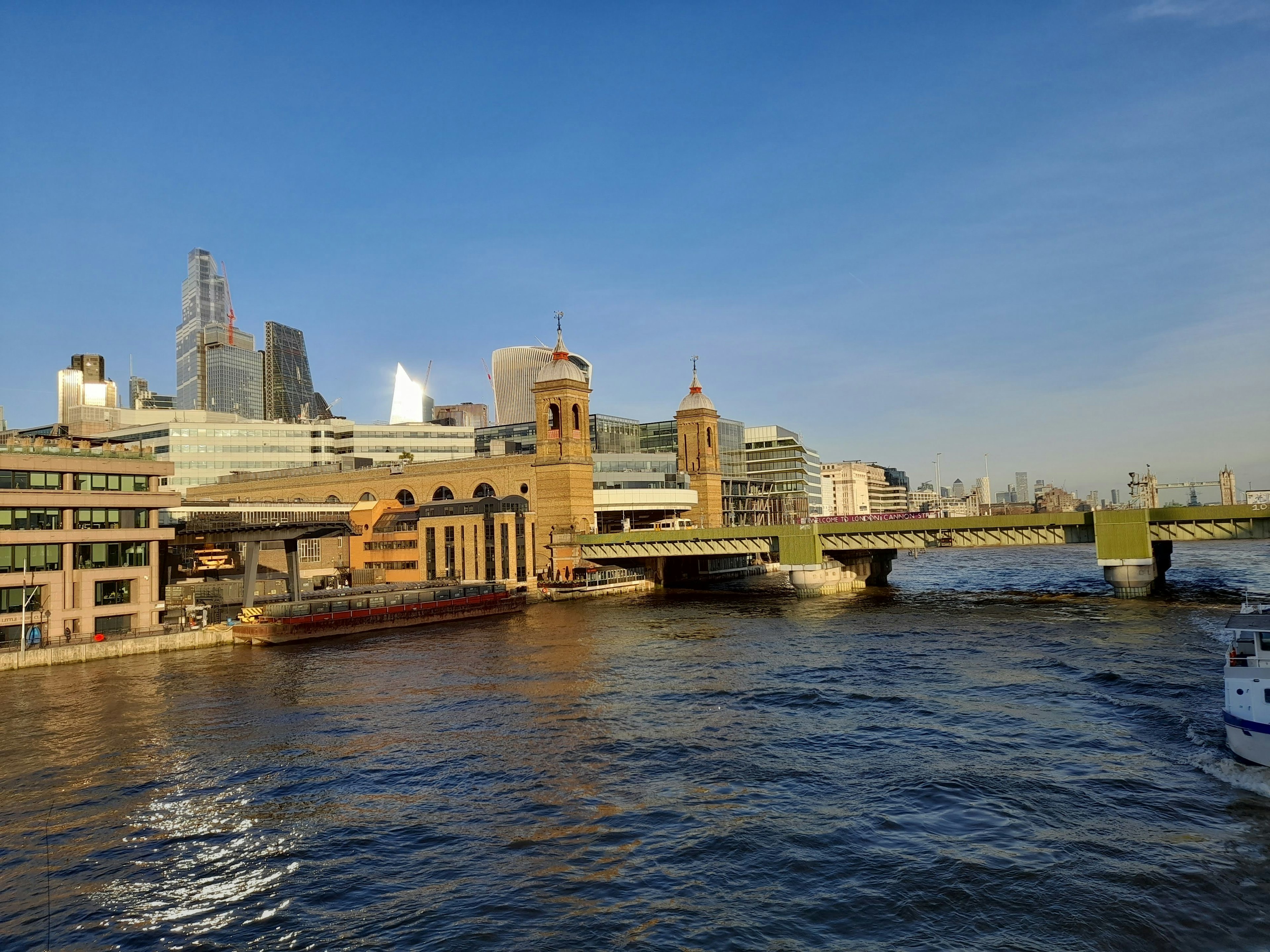 View of the Thames River in London with modern skyscrapers and historic buildings