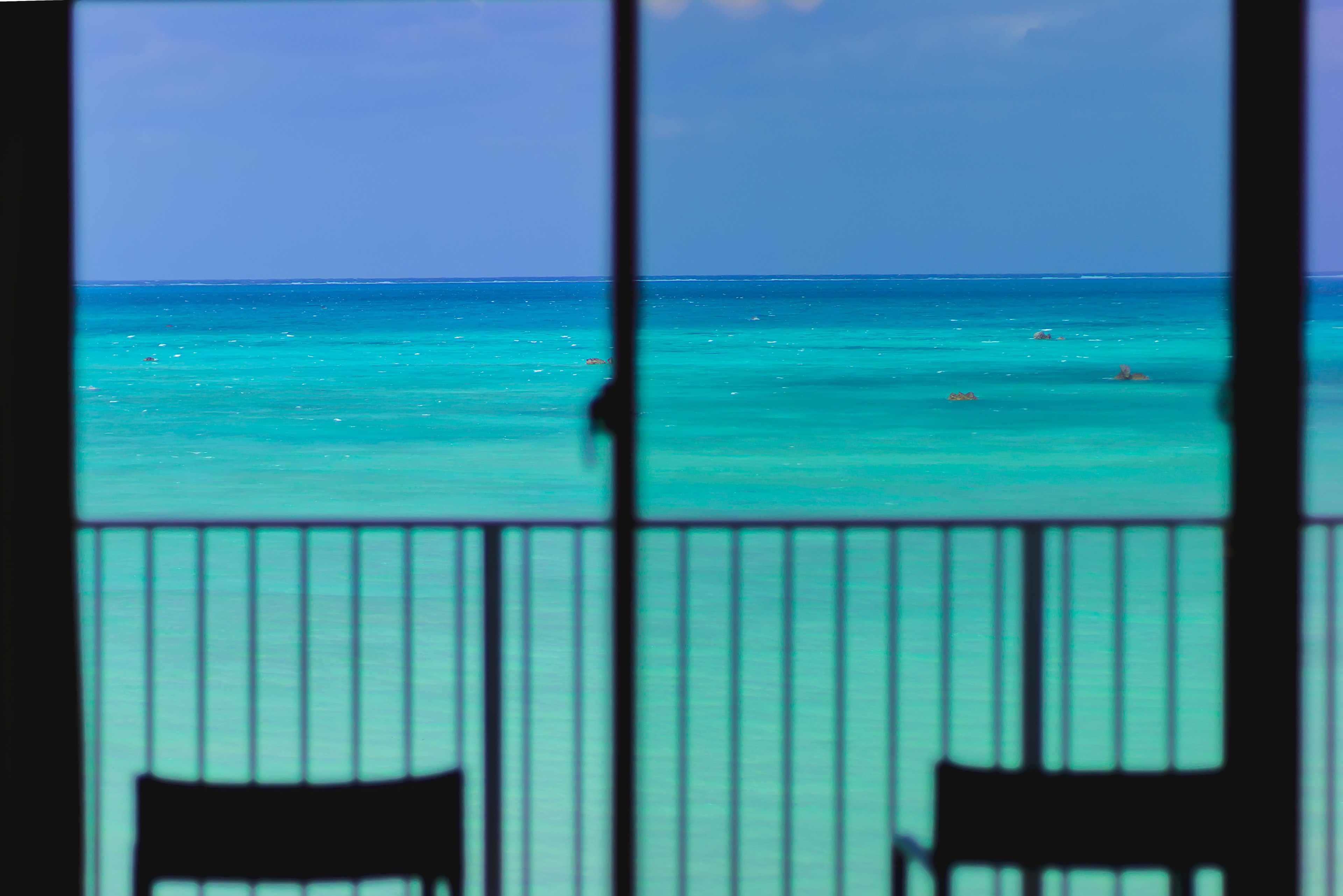 Blick auf den Ozean von einem Balkon mit zwei Stühlen im Fokus