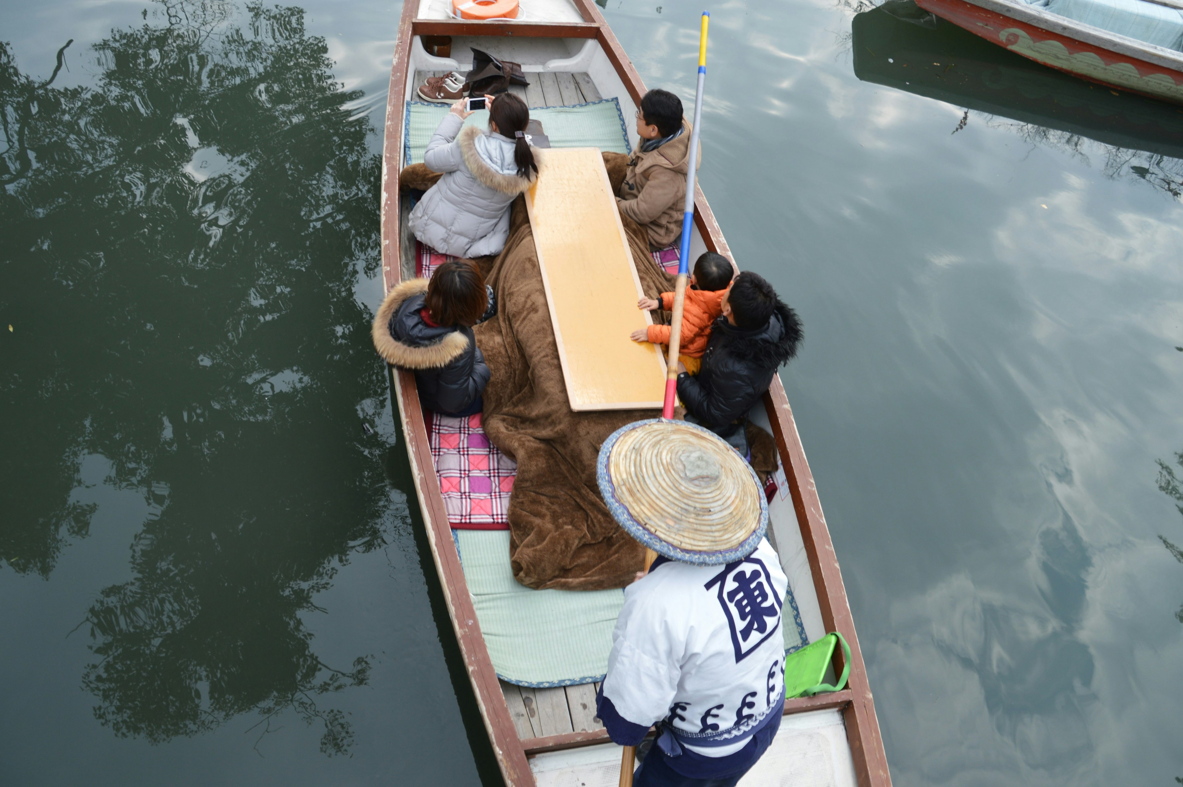 A group of people sitting around a table on a boat floating on a river