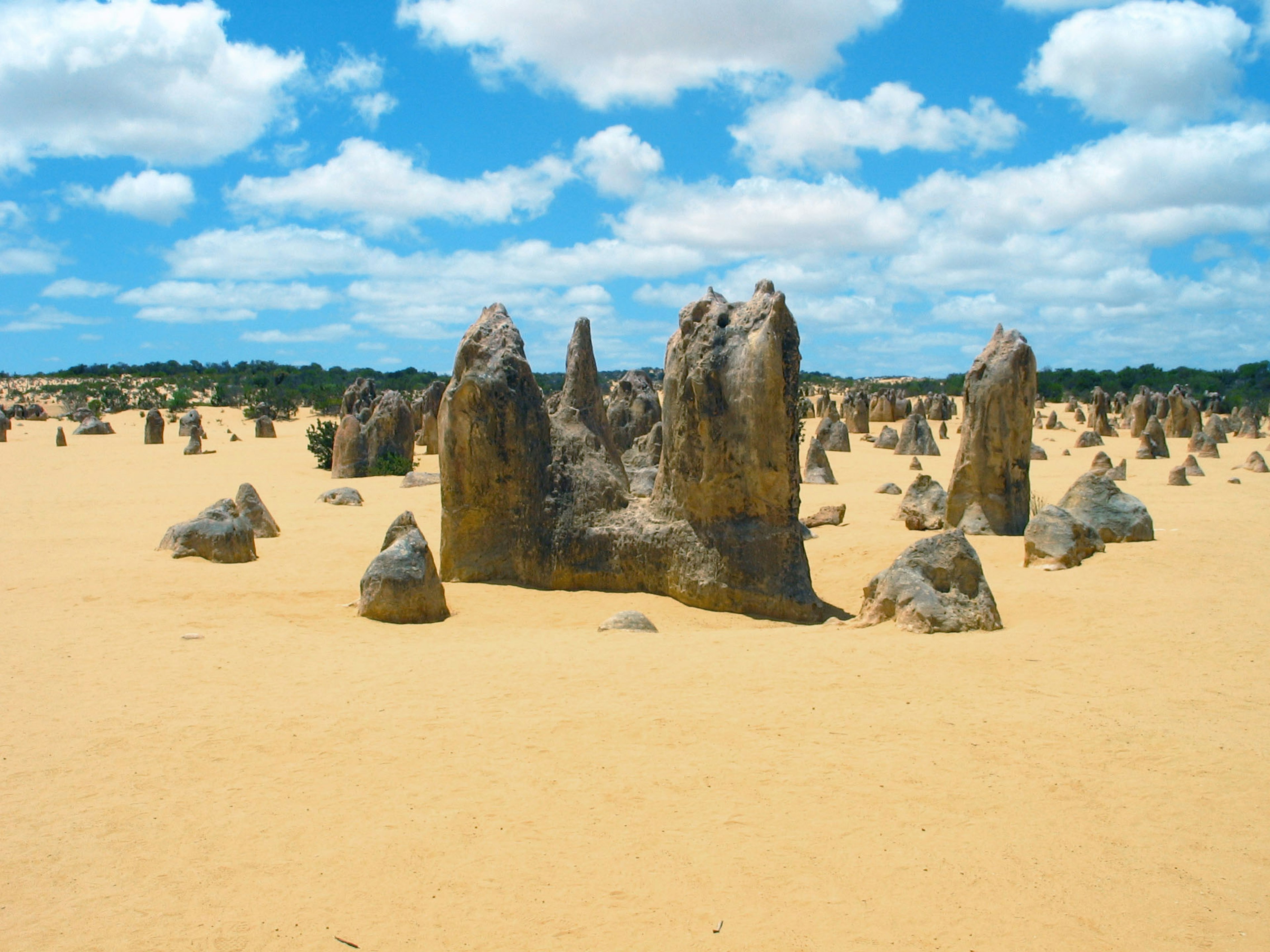 Irregular rock formations in a desert landscape under a blue sky