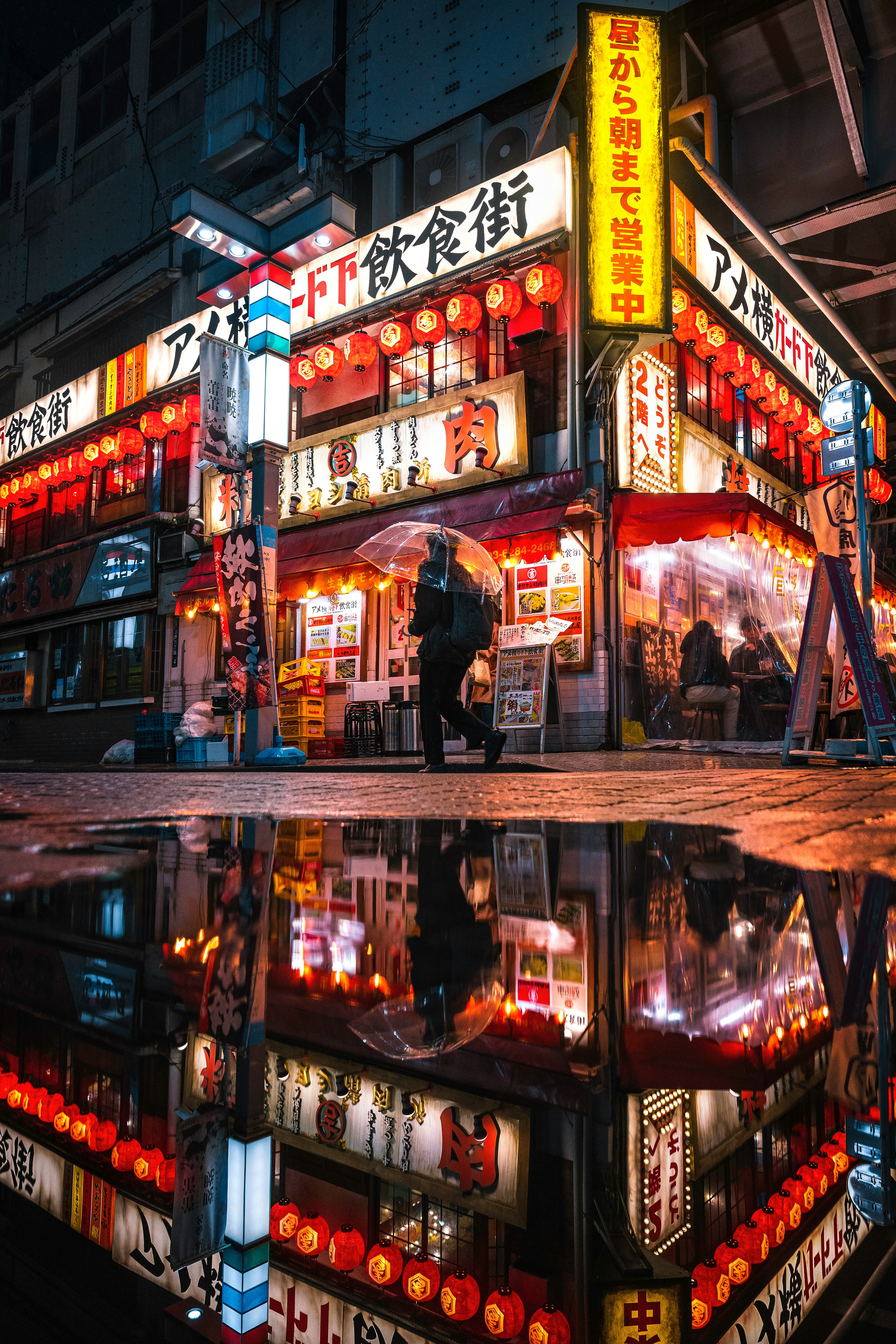 Scène animée d'une rue de nourriture japonaise avec des enseignes au néon et des reflets dans une flaque