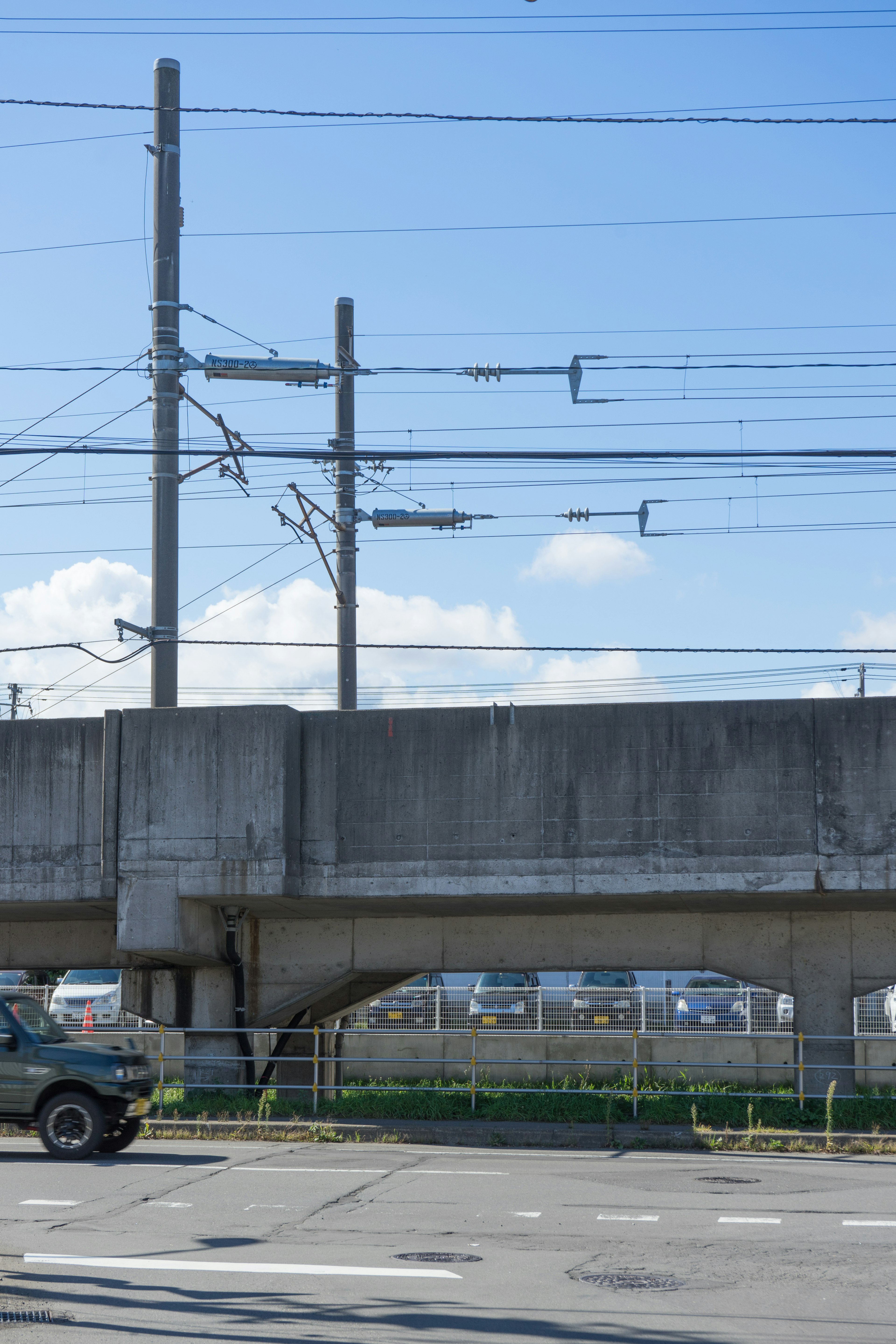 Paso elevado de concreto con líneas eléctricas bajo un cielo despejado