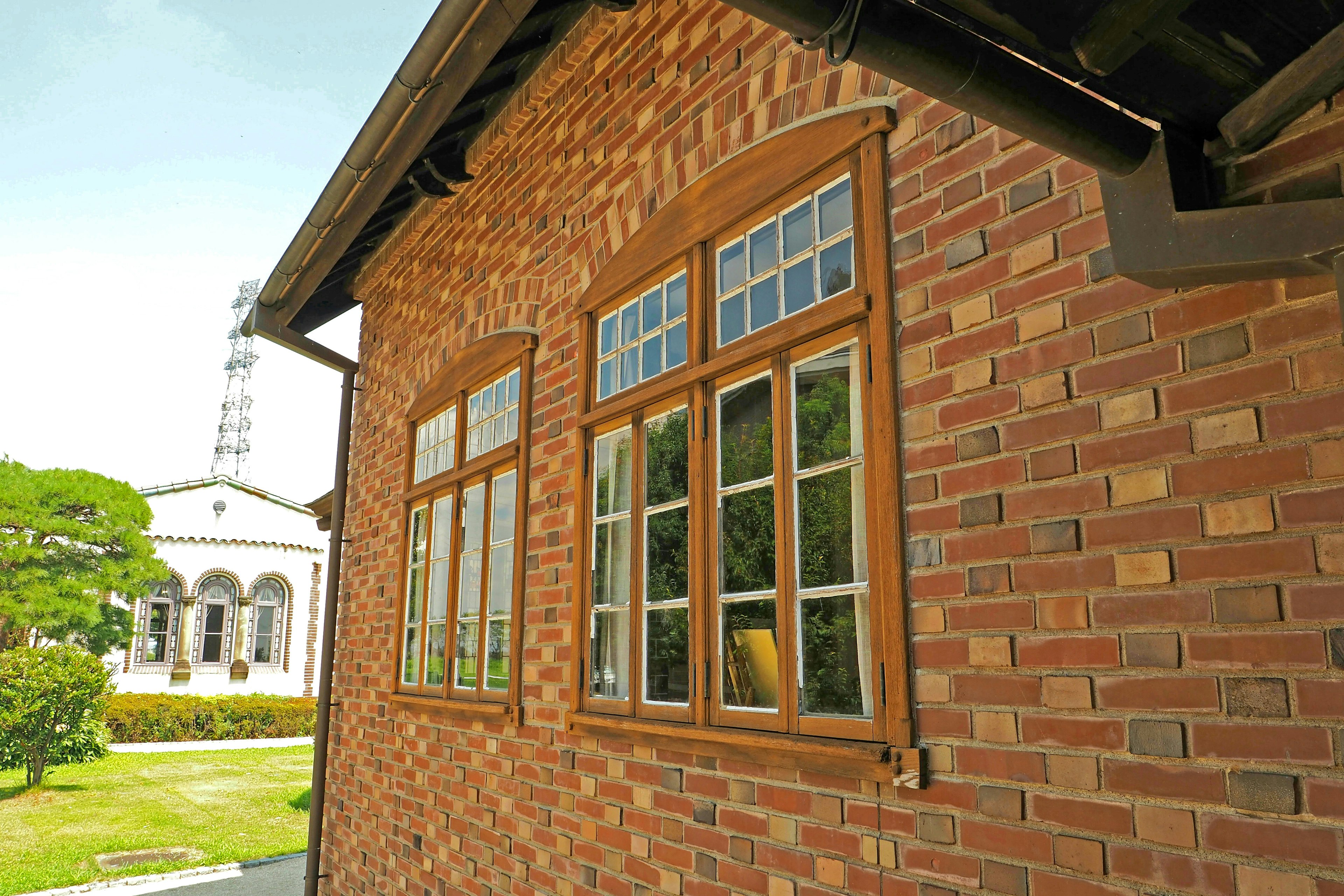 Exterior view of a historic building featuring red brick walls and wooden windows