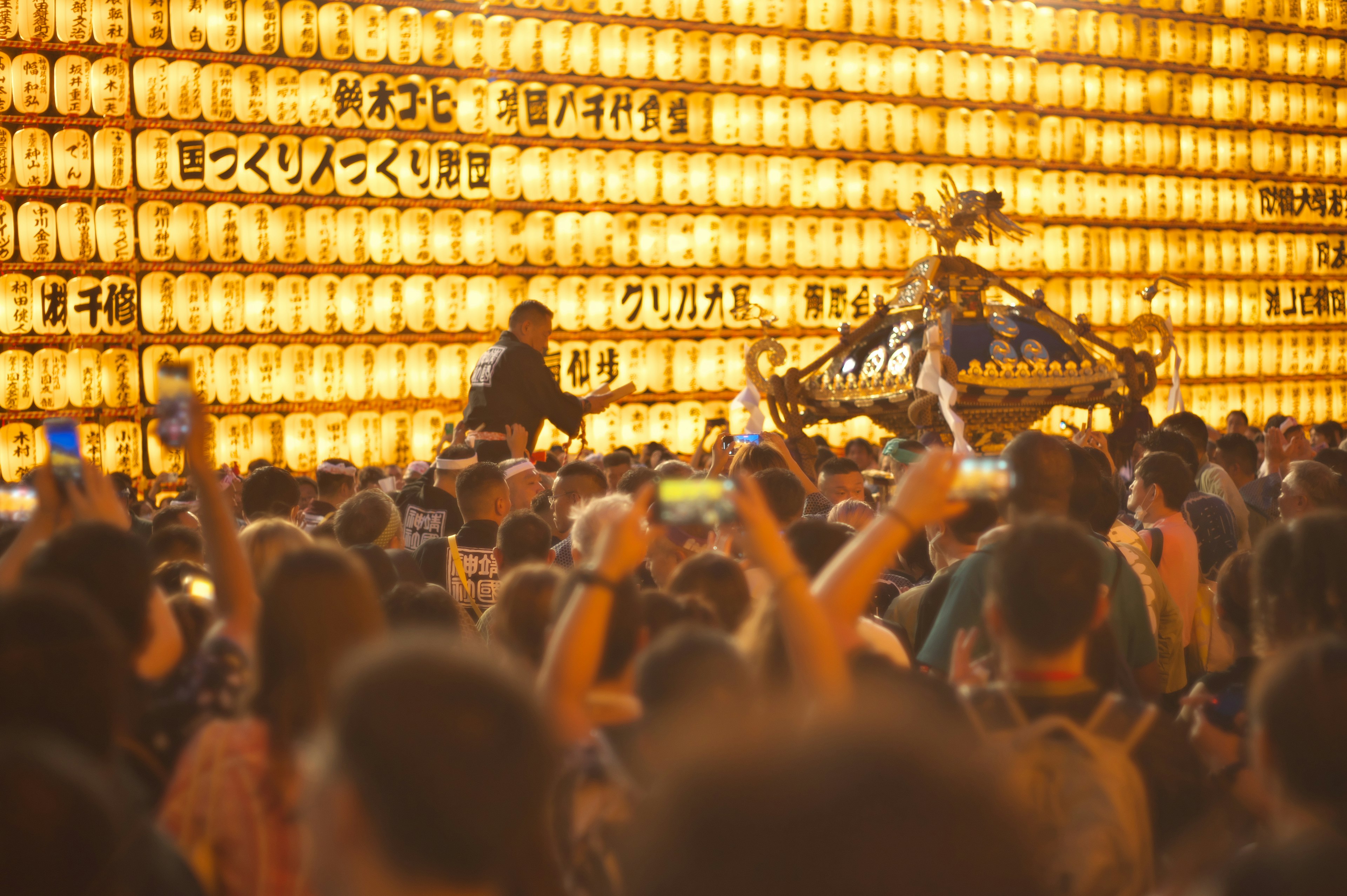 Folla a un festival con uno sfondo di lanterne luminose