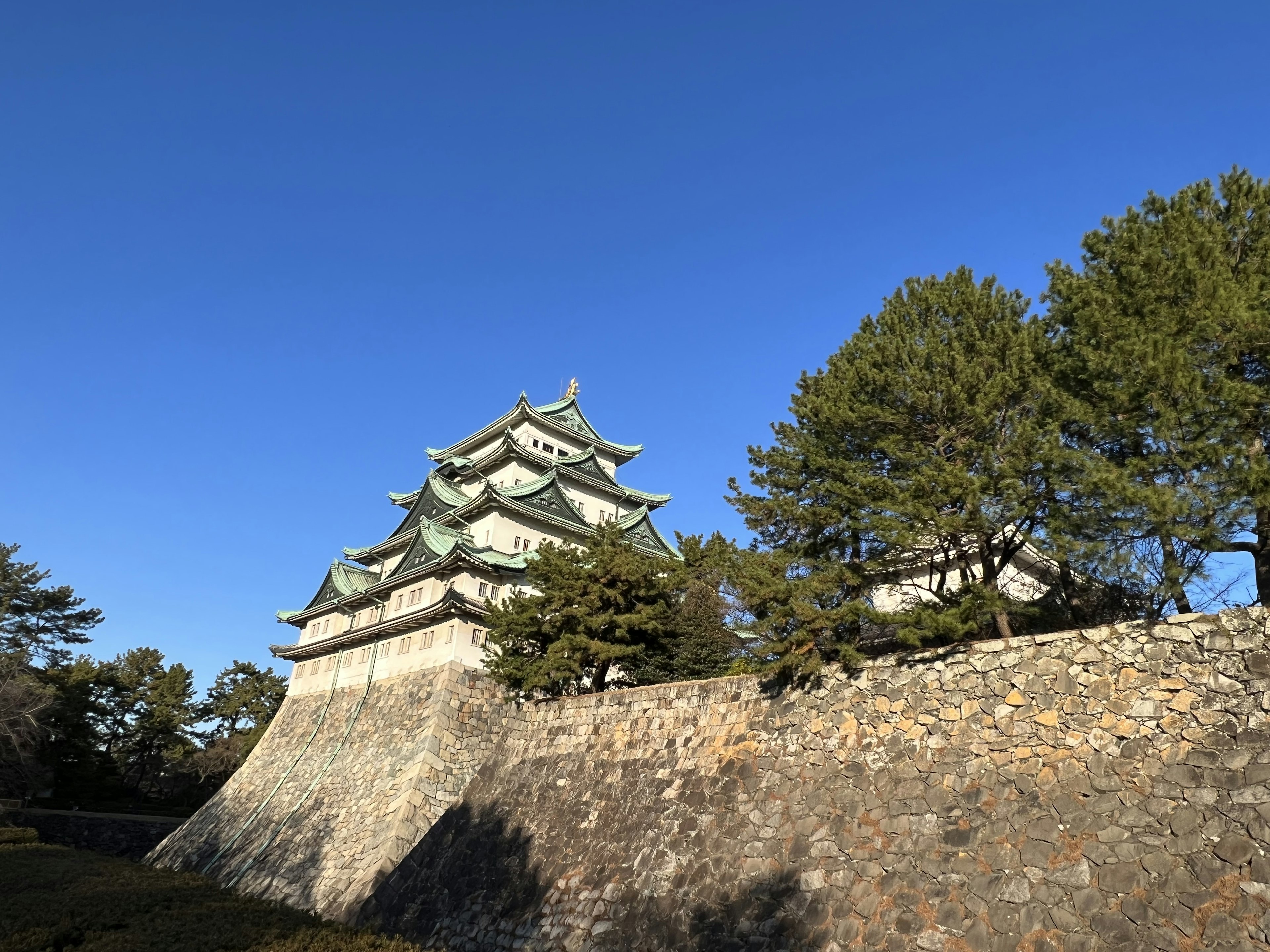 Japanese castle with distinctive architecture under a clear blue sky