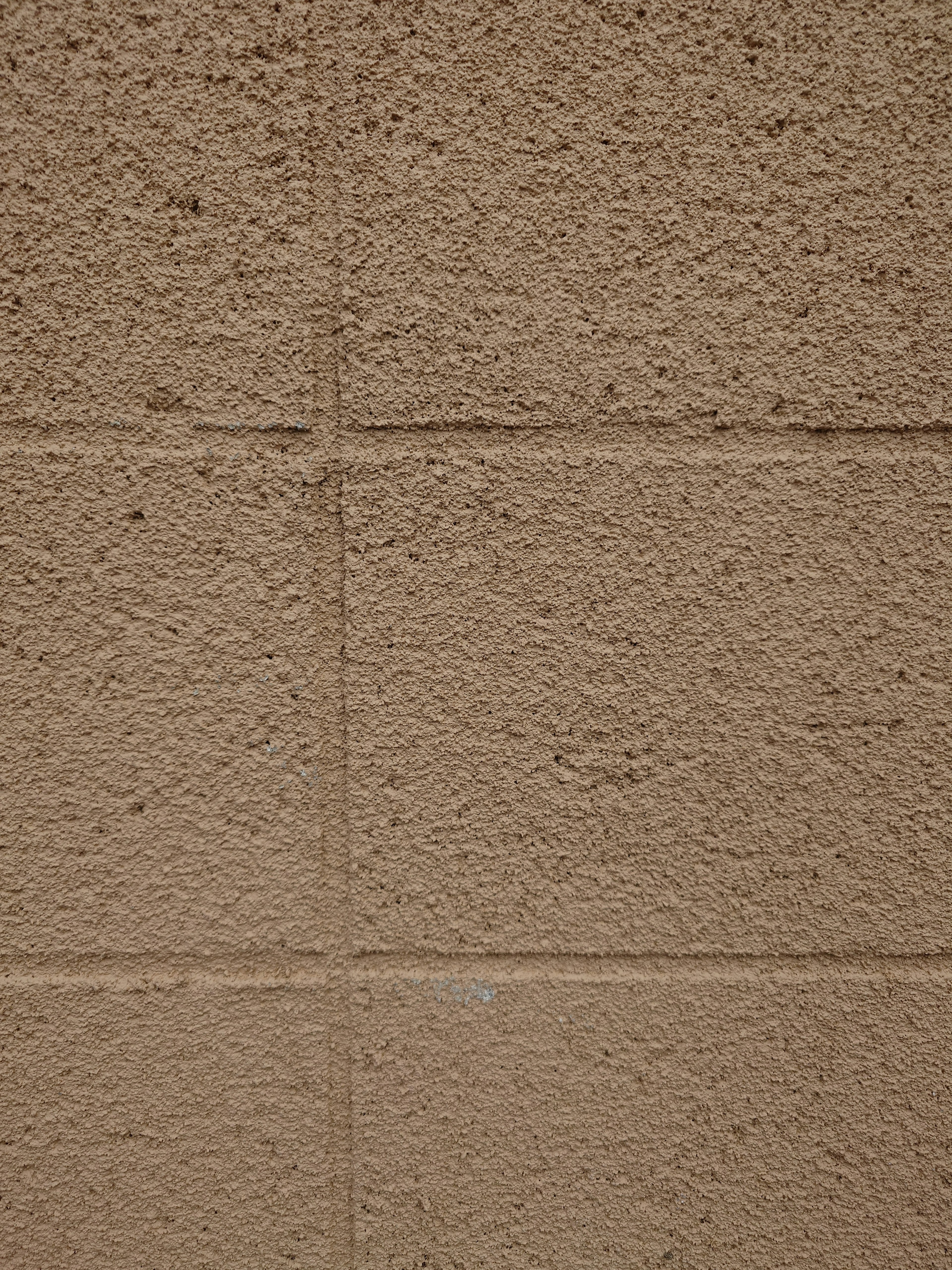 Texture di un muro in cemento marrone con blocchi visibili