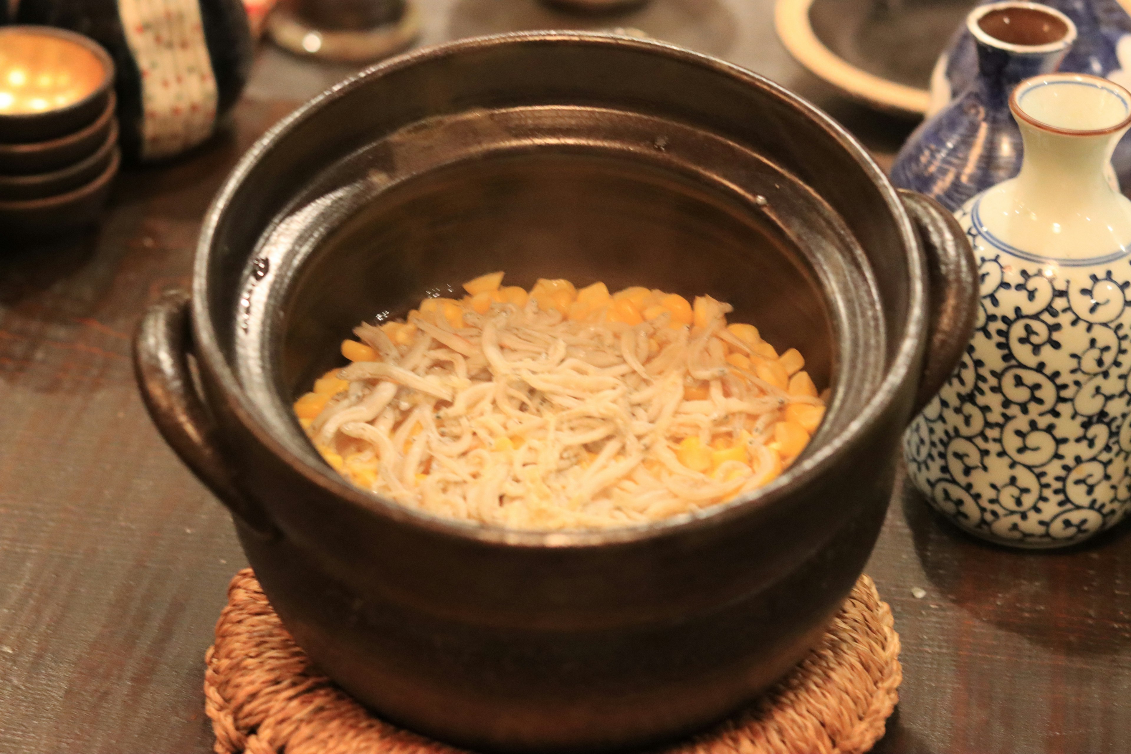 Un plato caliente con fideos finos en una olla negra