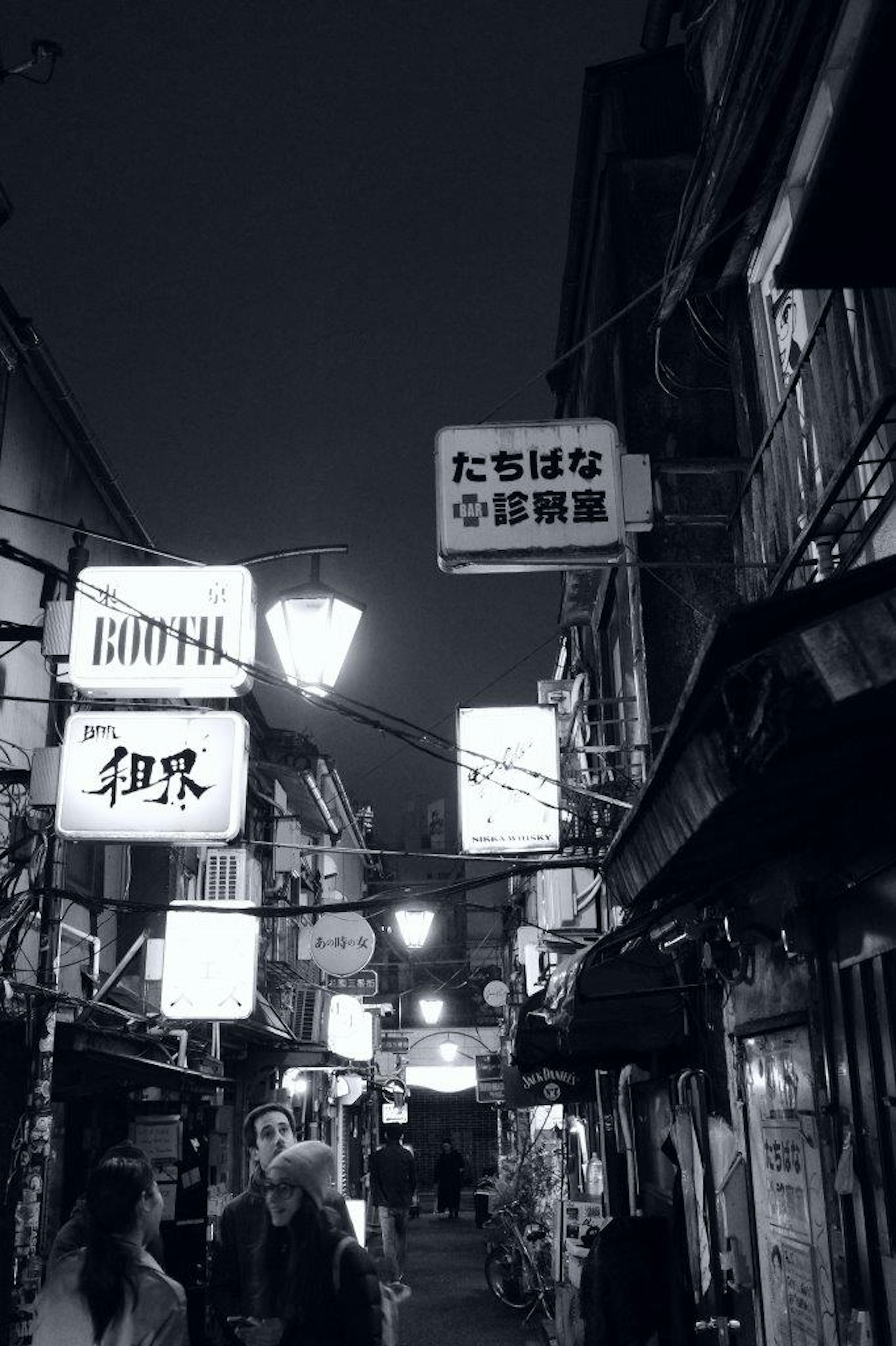 Callejón japonés iluminado por faroles y letreros de noche