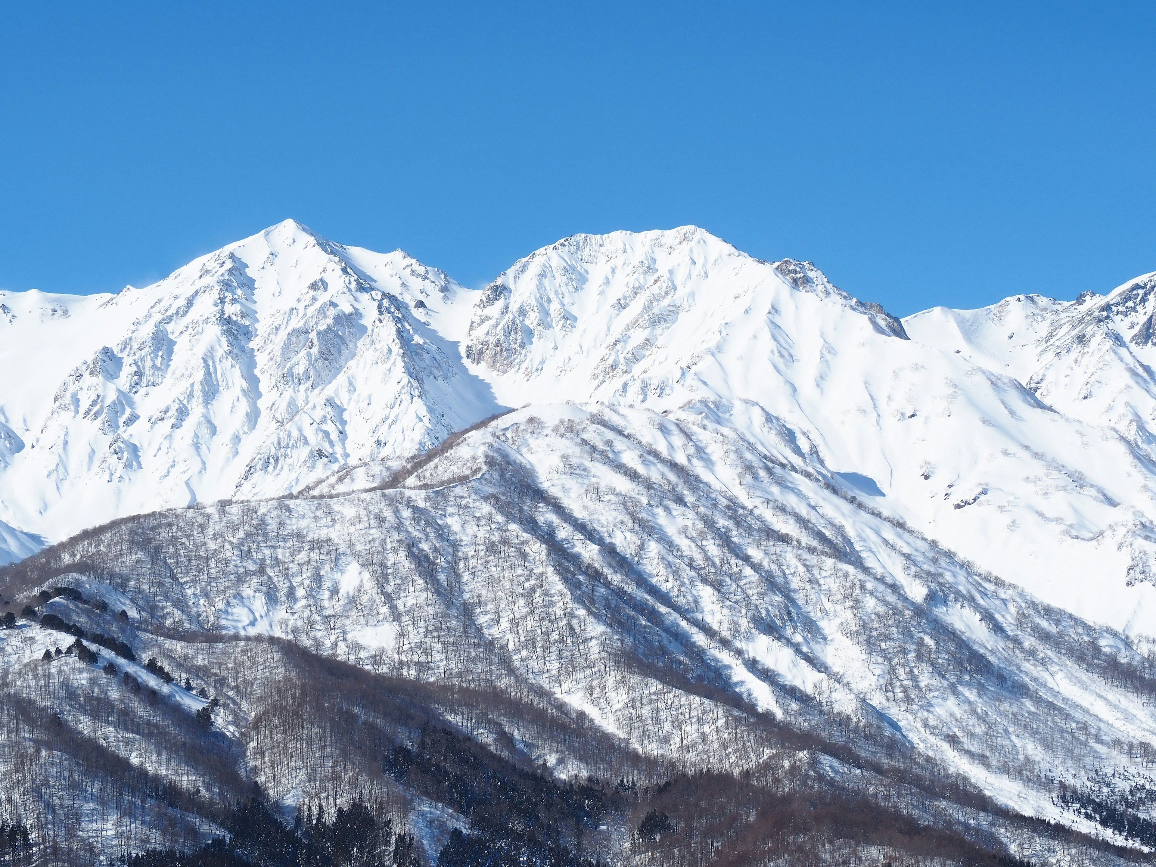 Snow-covered mountains under a clear blue sky