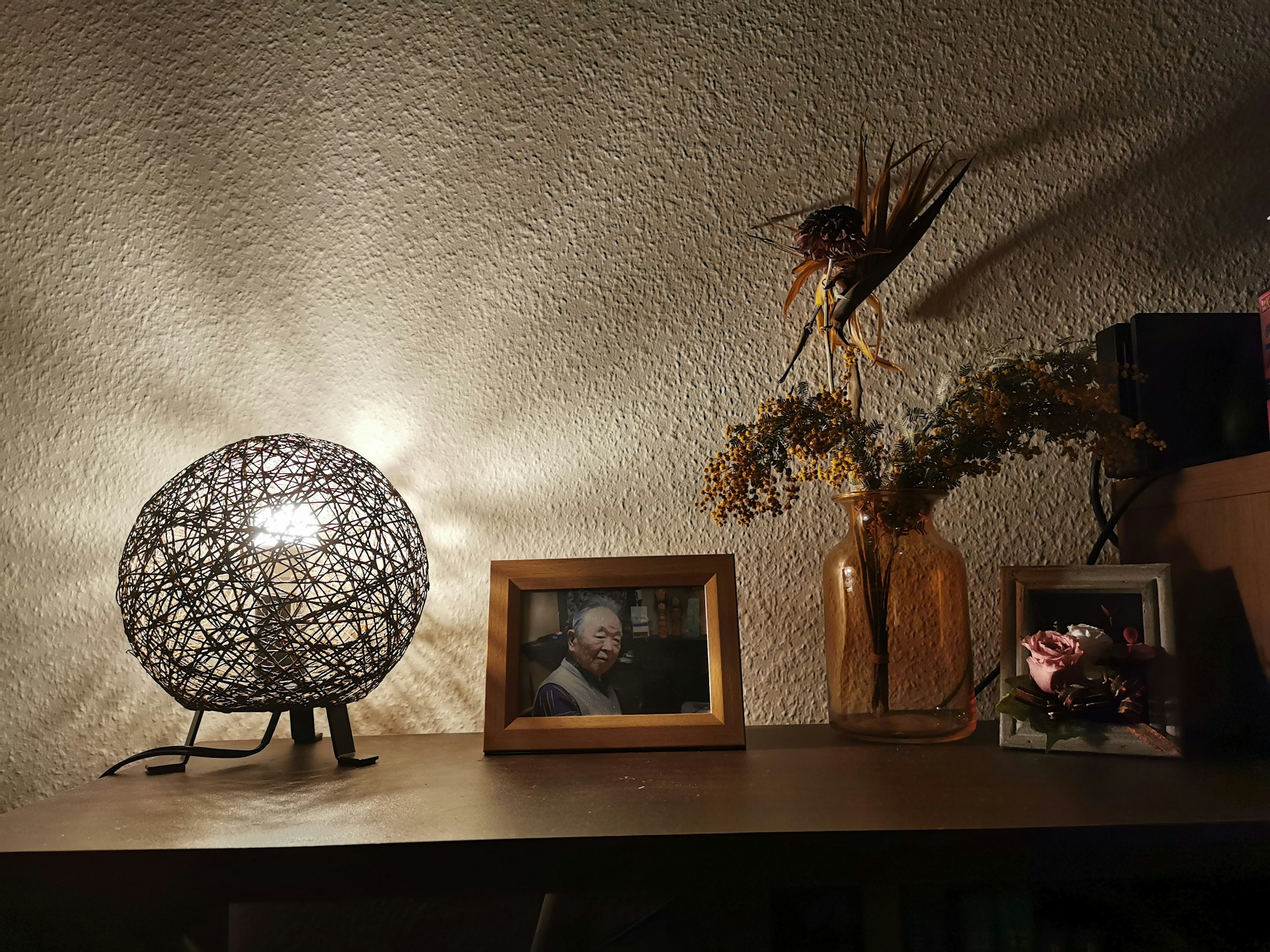 A decorative lamp and a vase with dried flowers on a table