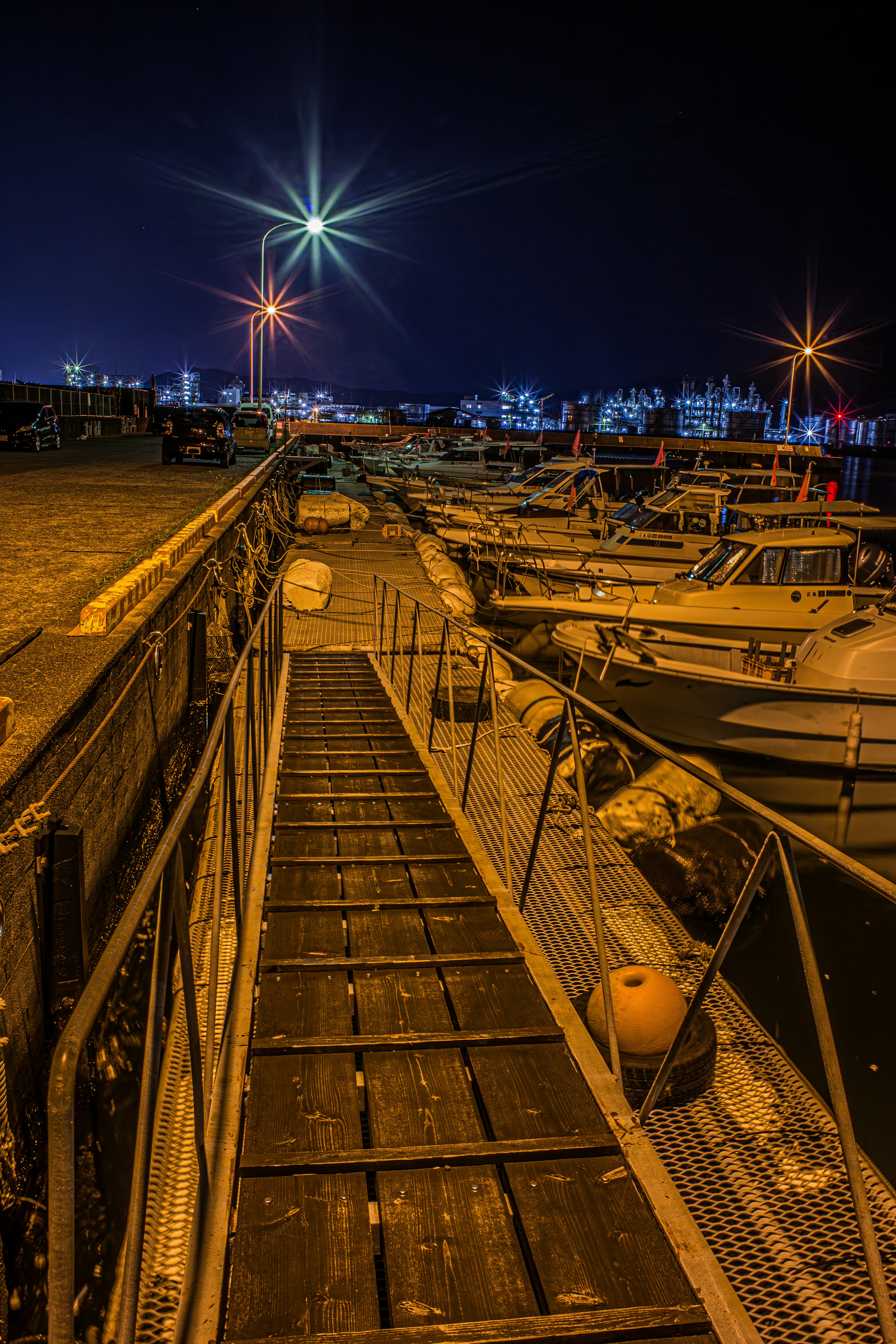 Pemandangan malam dermaga dengan perahu dan lampu terang