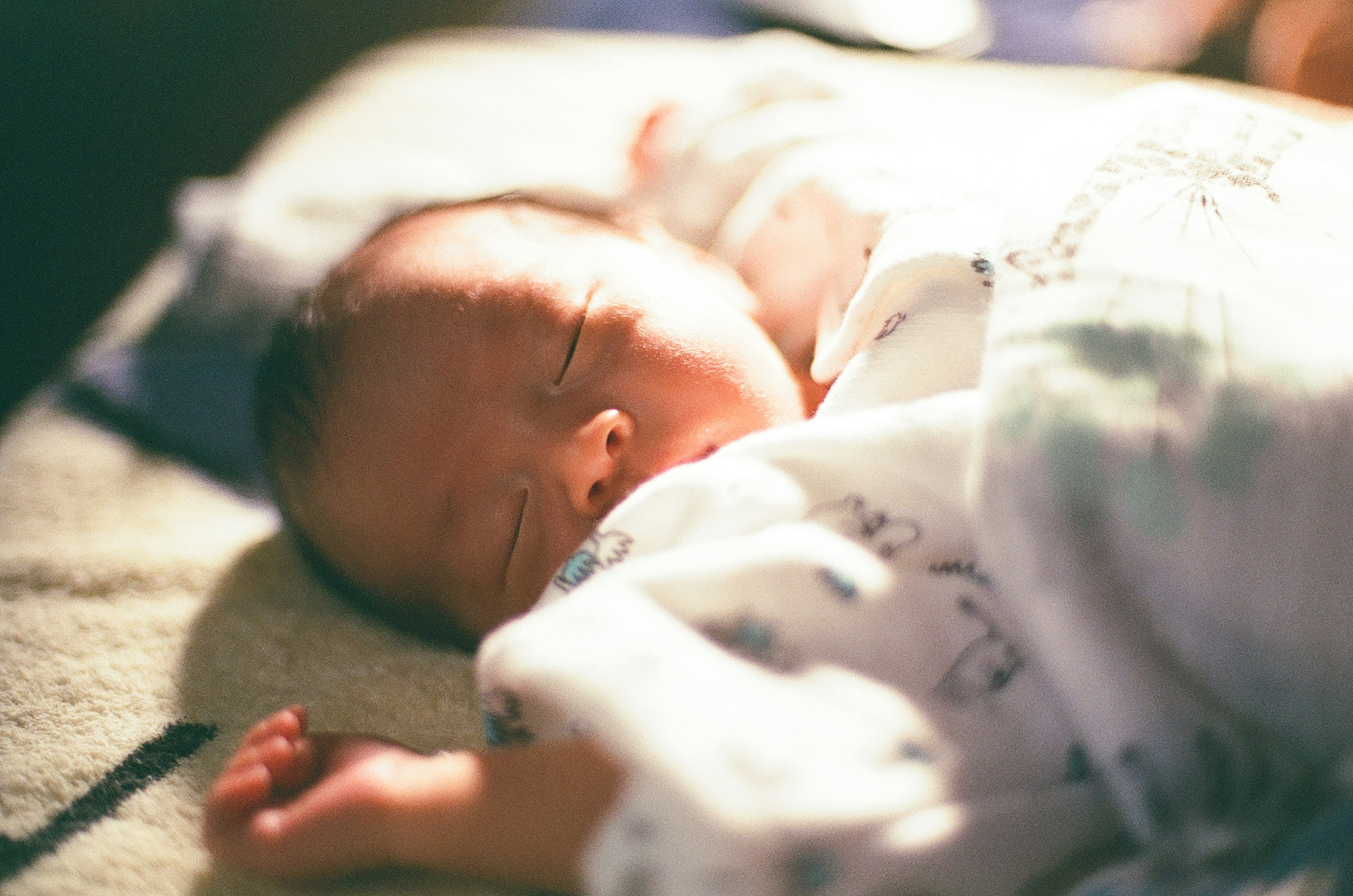 Un bambino che dorme avvolto in una coperta bianca