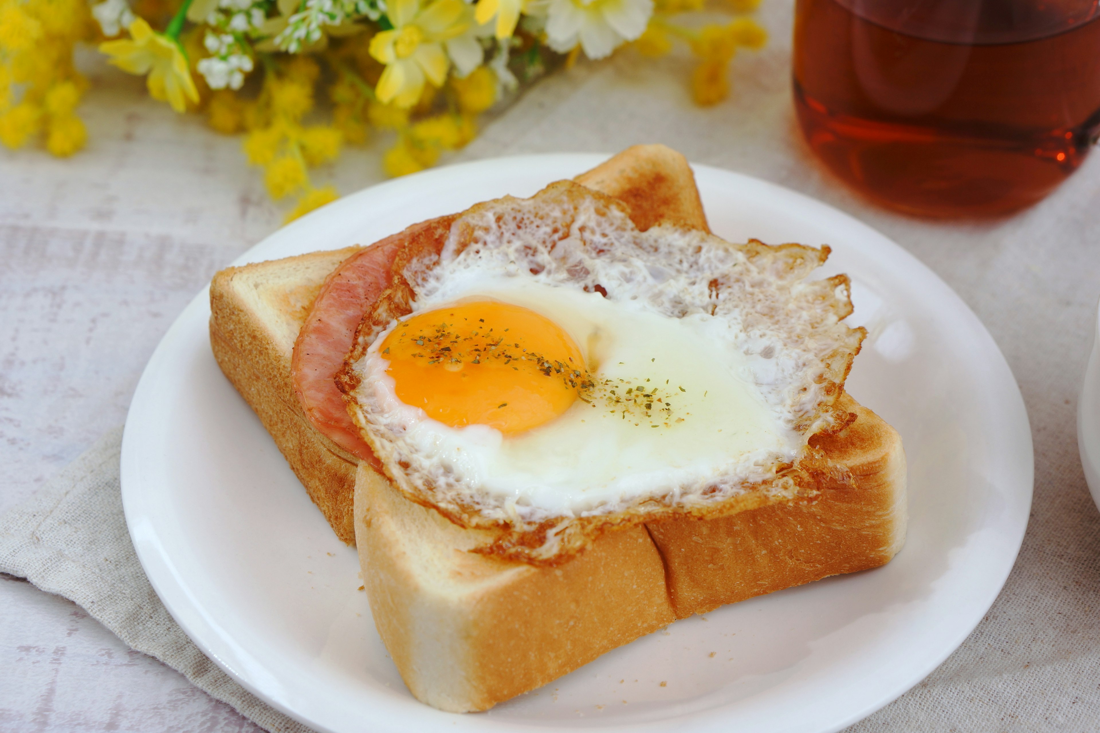 Frühstücksteller mit Toast, belegt mit Spiegelei und Schinken