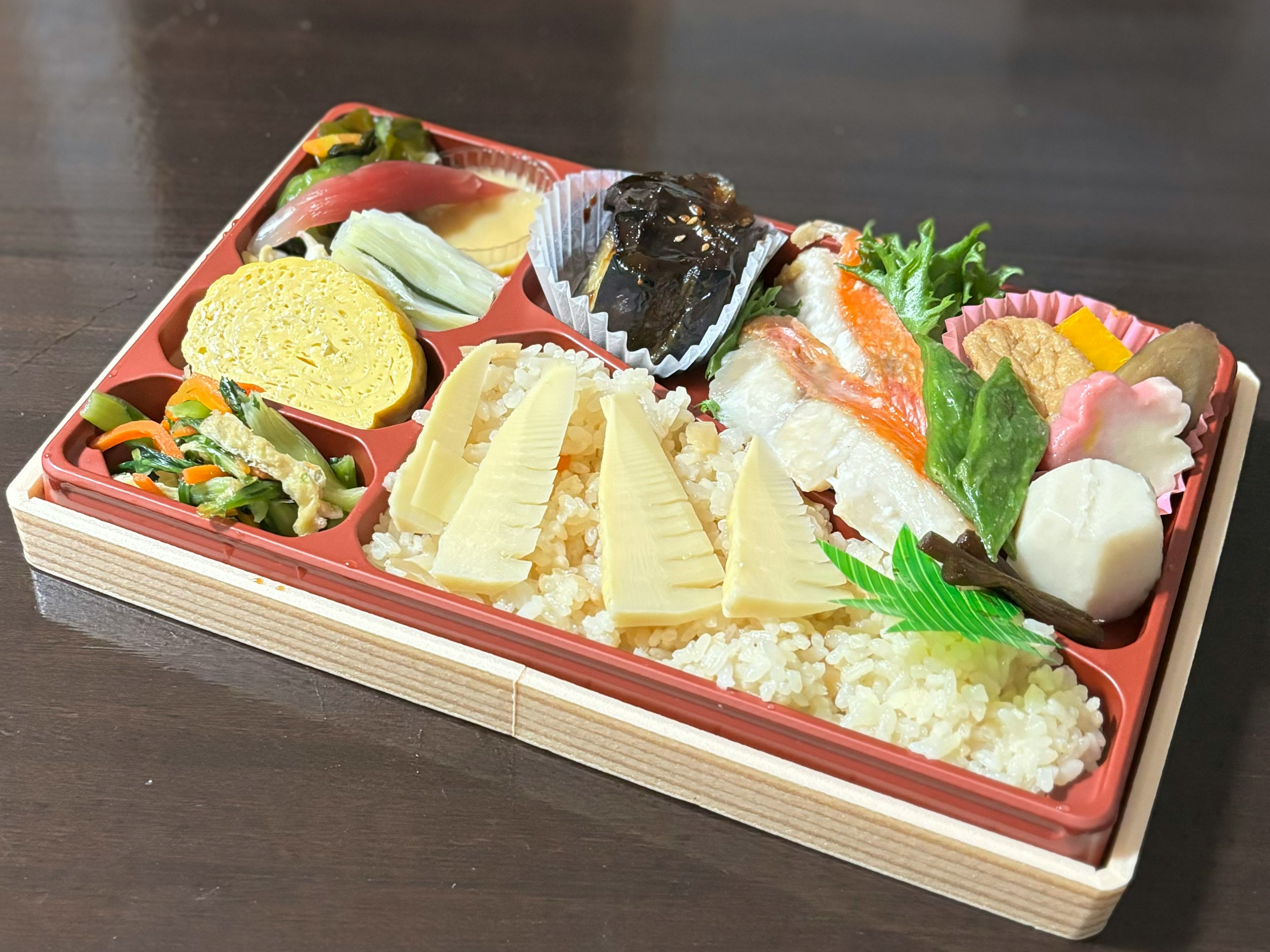 Une boîte à bento japonaise avec des sushis colorés et des plats d'accompagnement