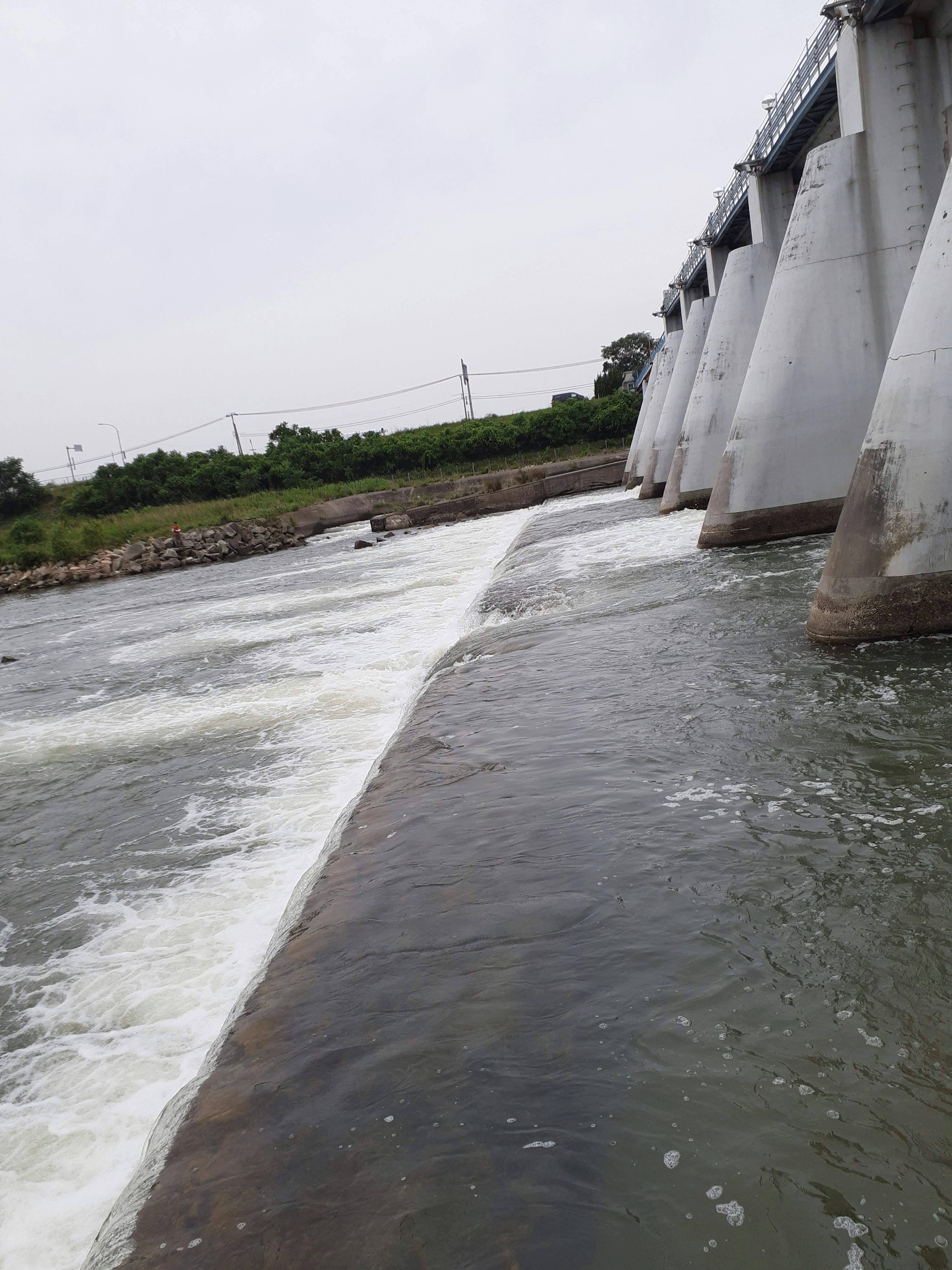 Un paysage montrant une rivière et une structure de barrage L'eau s'écoulant sous le barrage