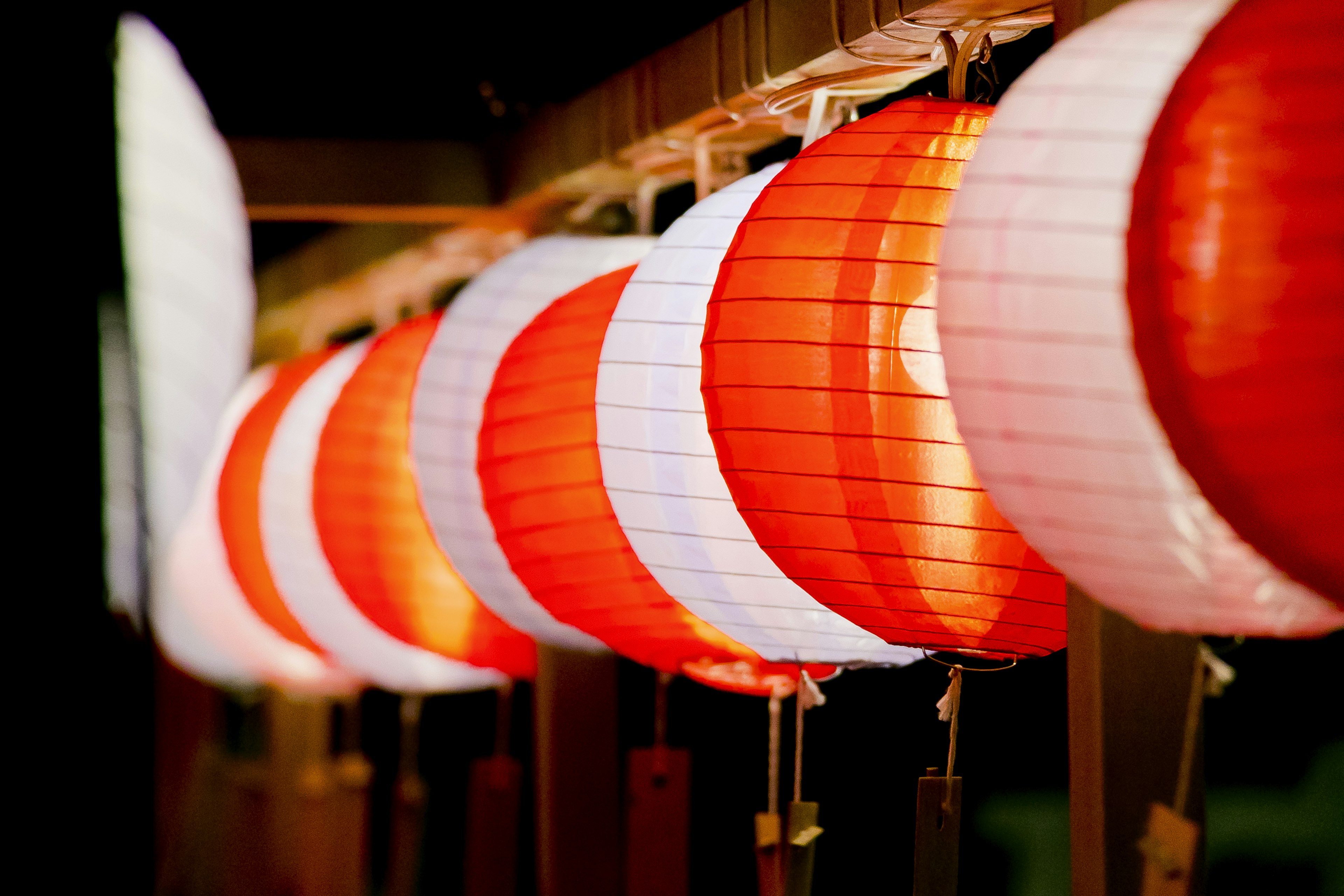 Row of red and white lanterns illuminated at night