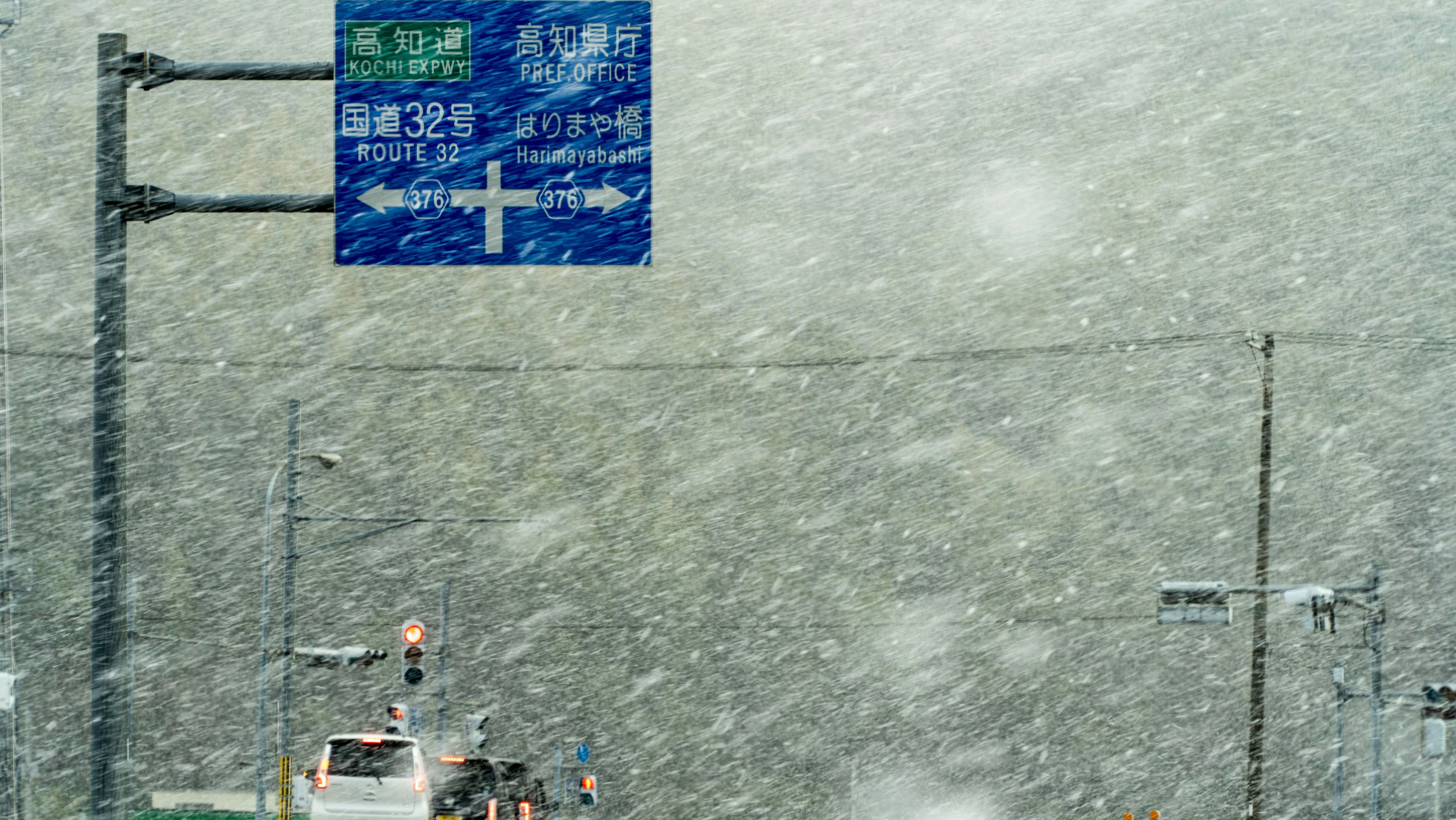 激しい吹雪の中にある交通標識と道路