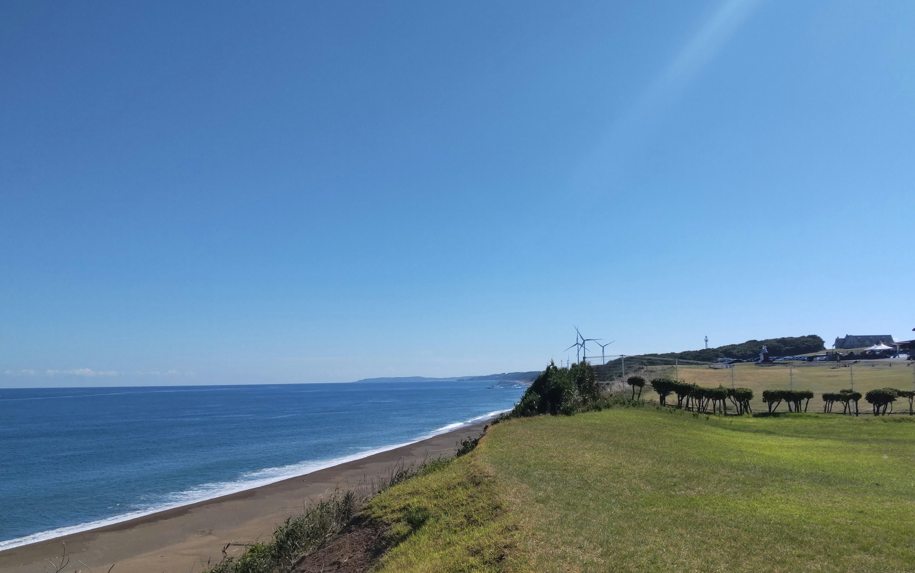 Vista panoramica dell'oceano blu e del cielo sereno prato verde e case lontane