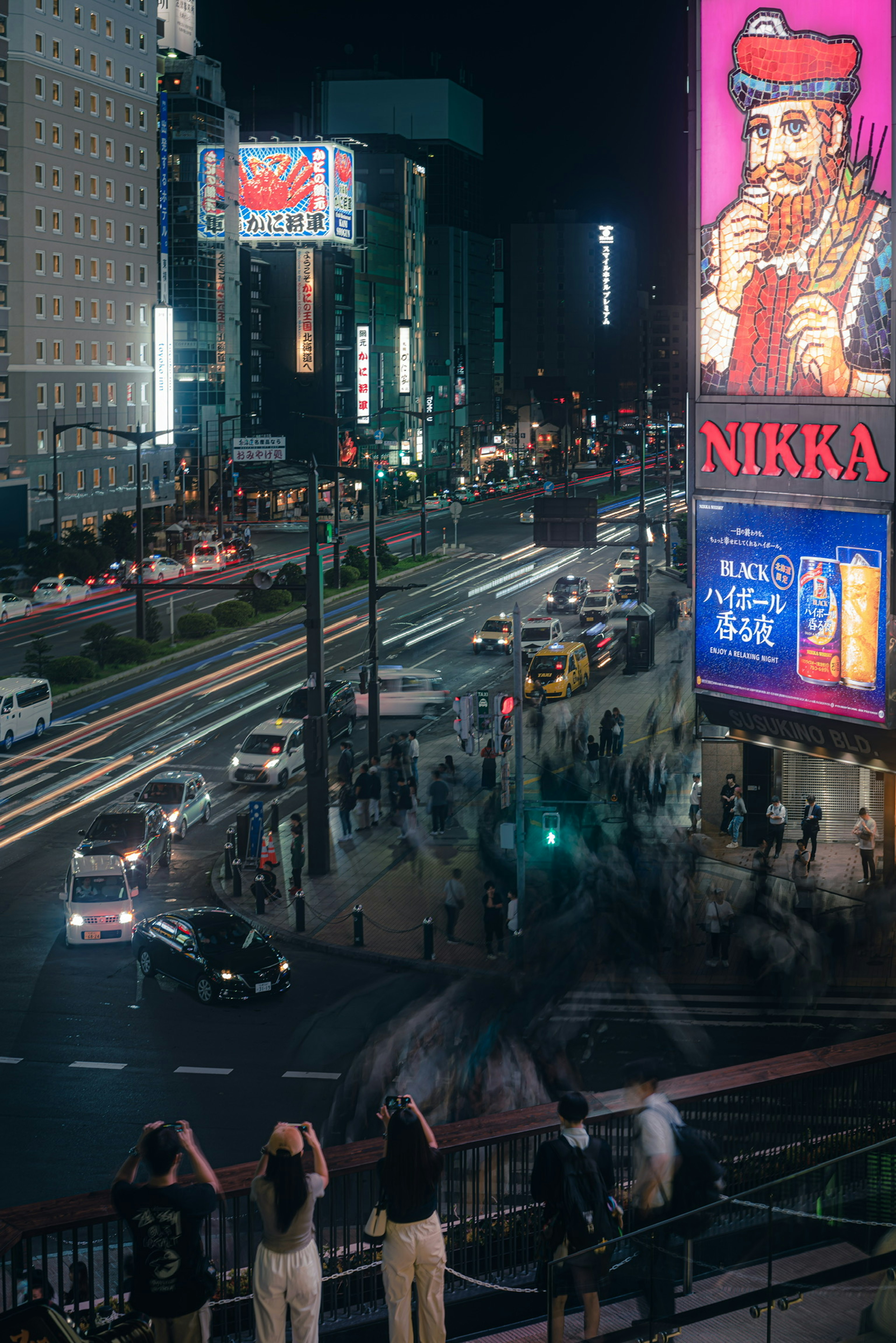 Pemandangan kota yang hidup di malam hari dengan papan iklan neon dan lalu lintas yang ramai