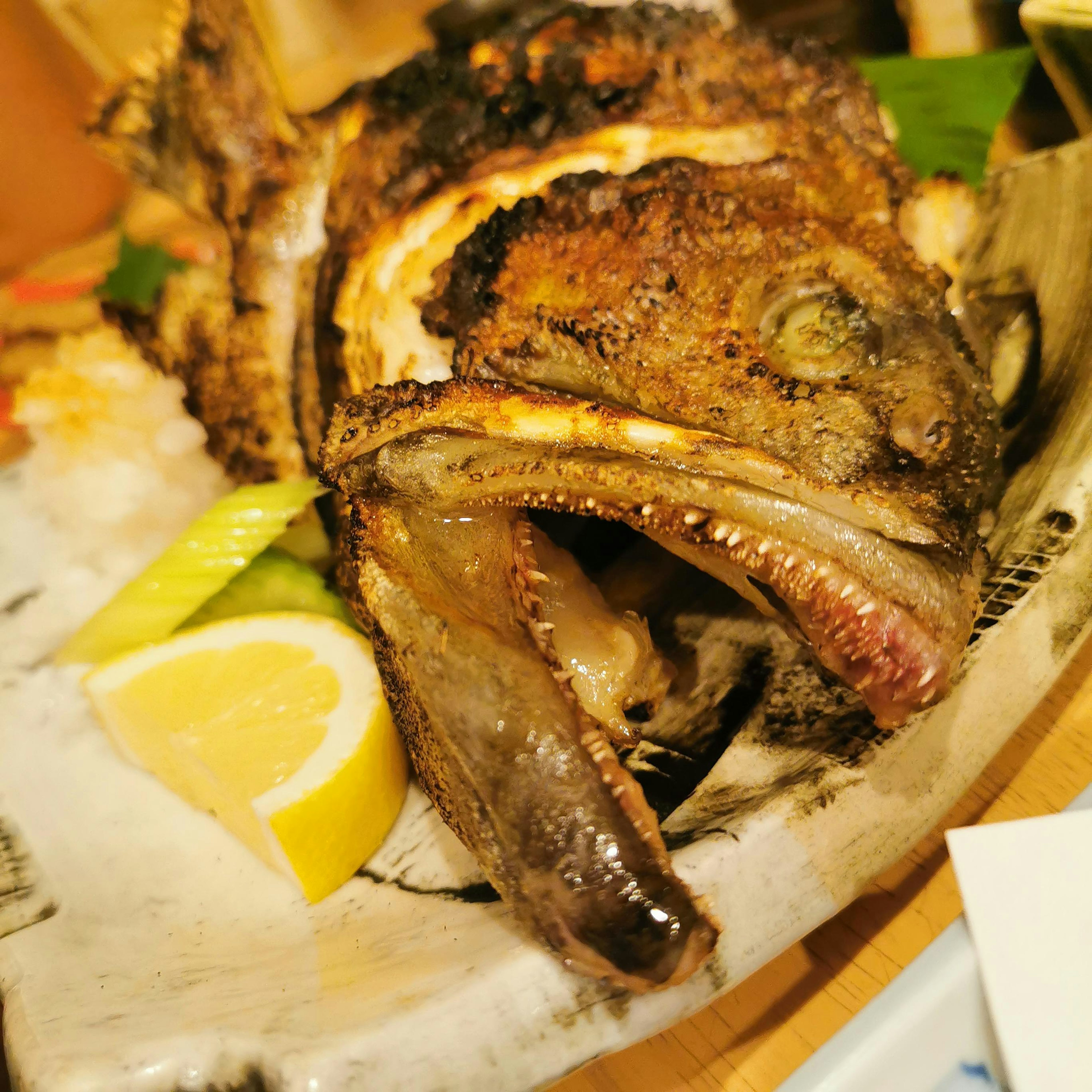 Grilled fish served on a plate with lemon and vegetables