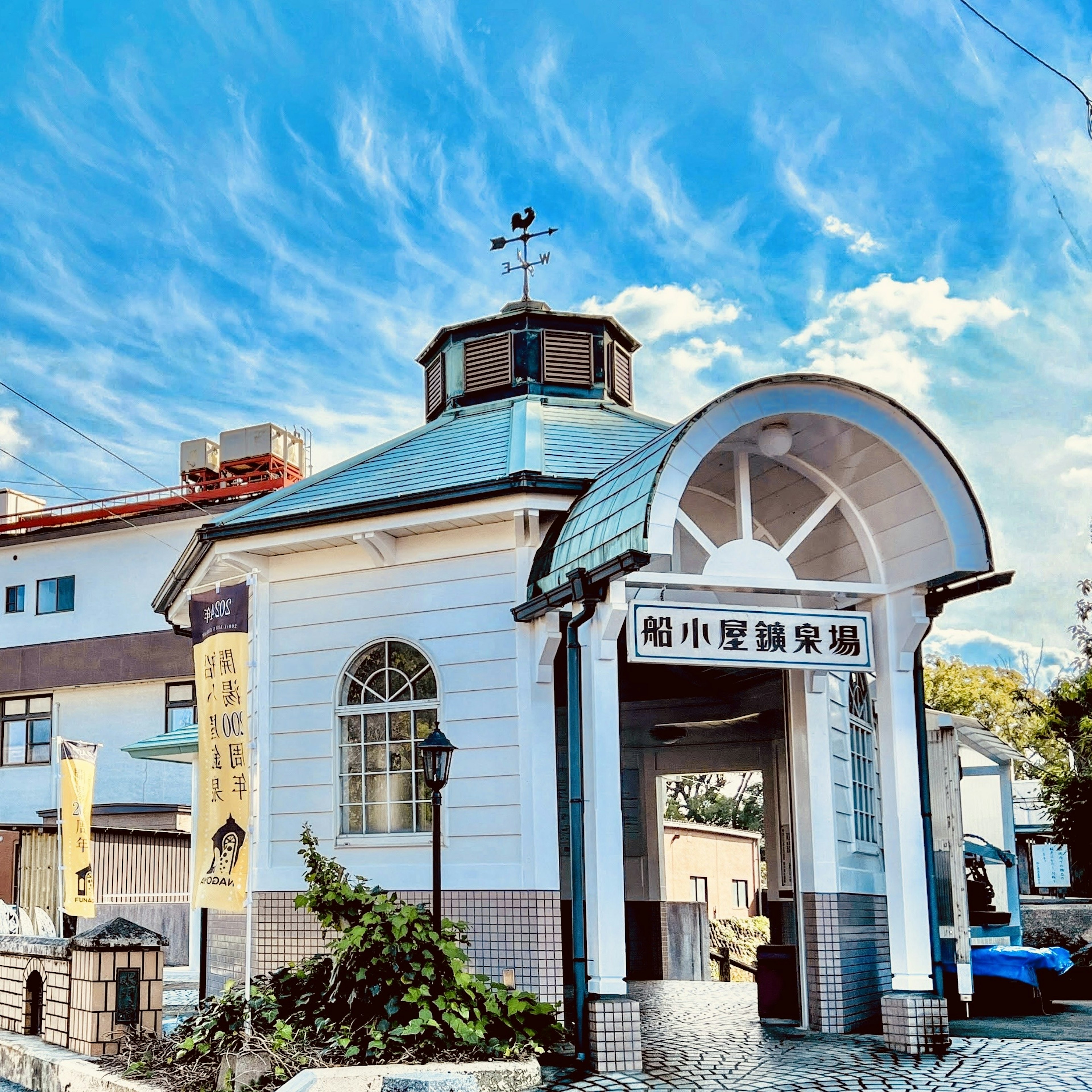 Charming white building with a decorative roof and blue sky