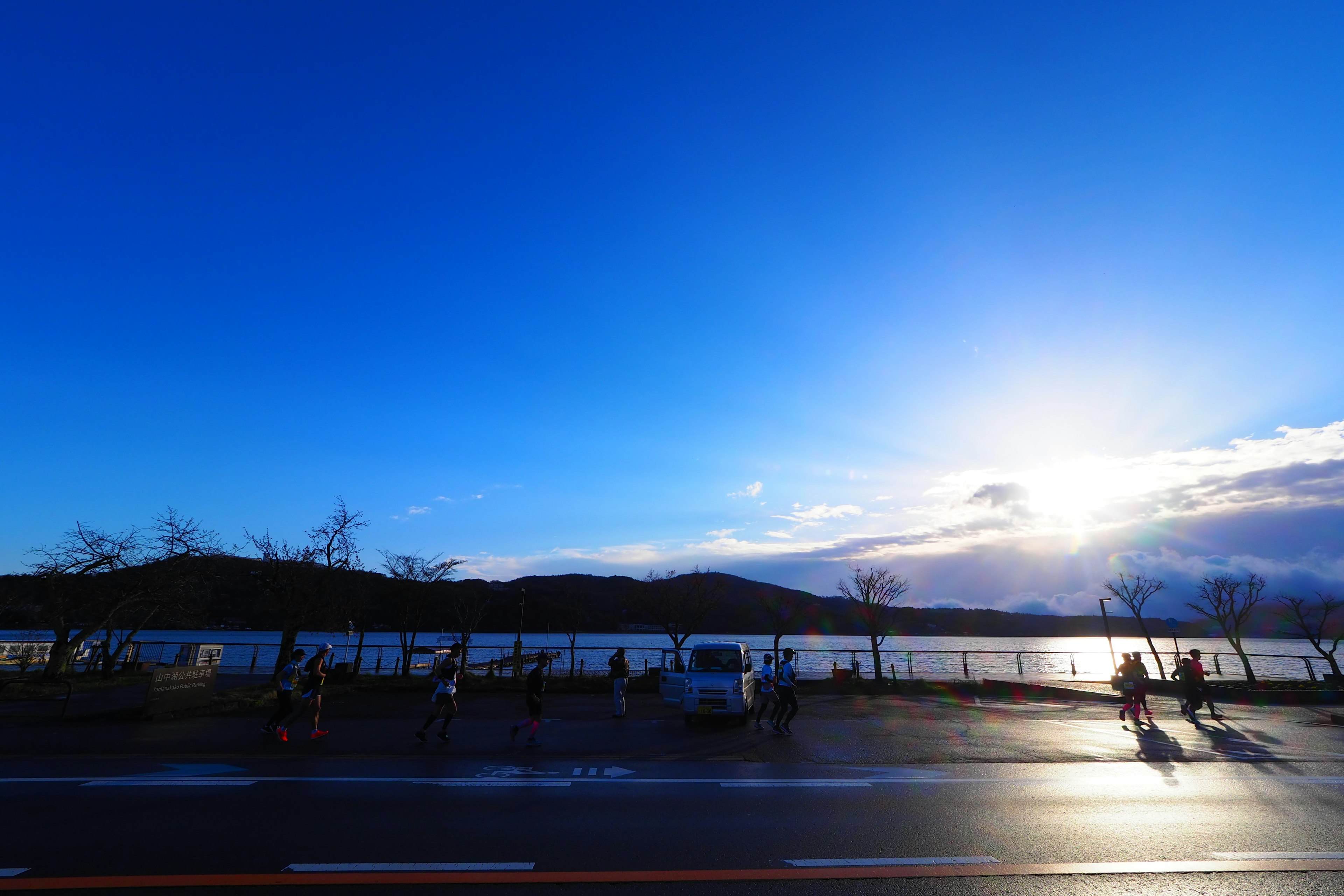 青い空と水面が広がる風景 夕日の光が反射する