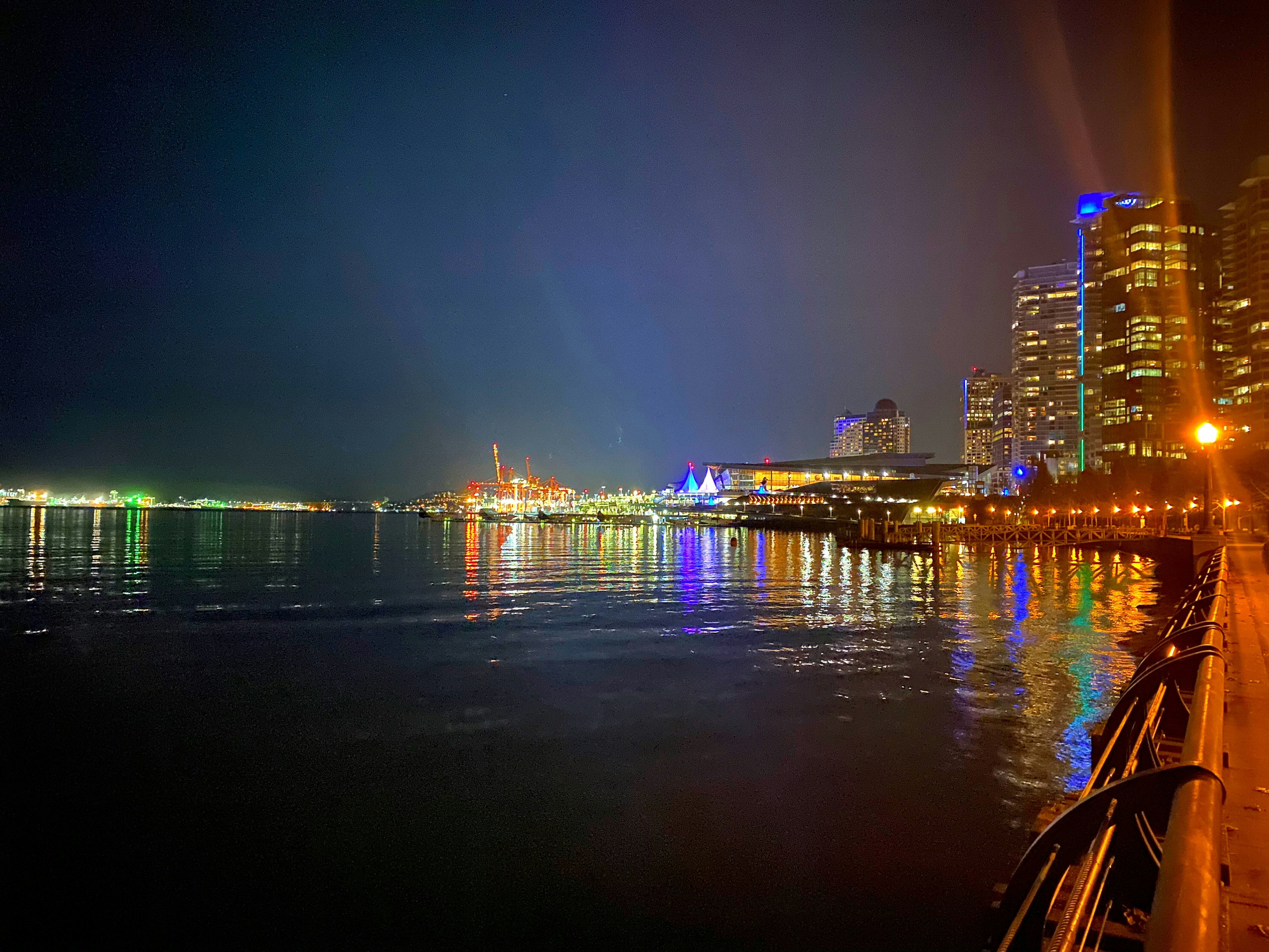 Vista nocturna del mar con edificios iluminados