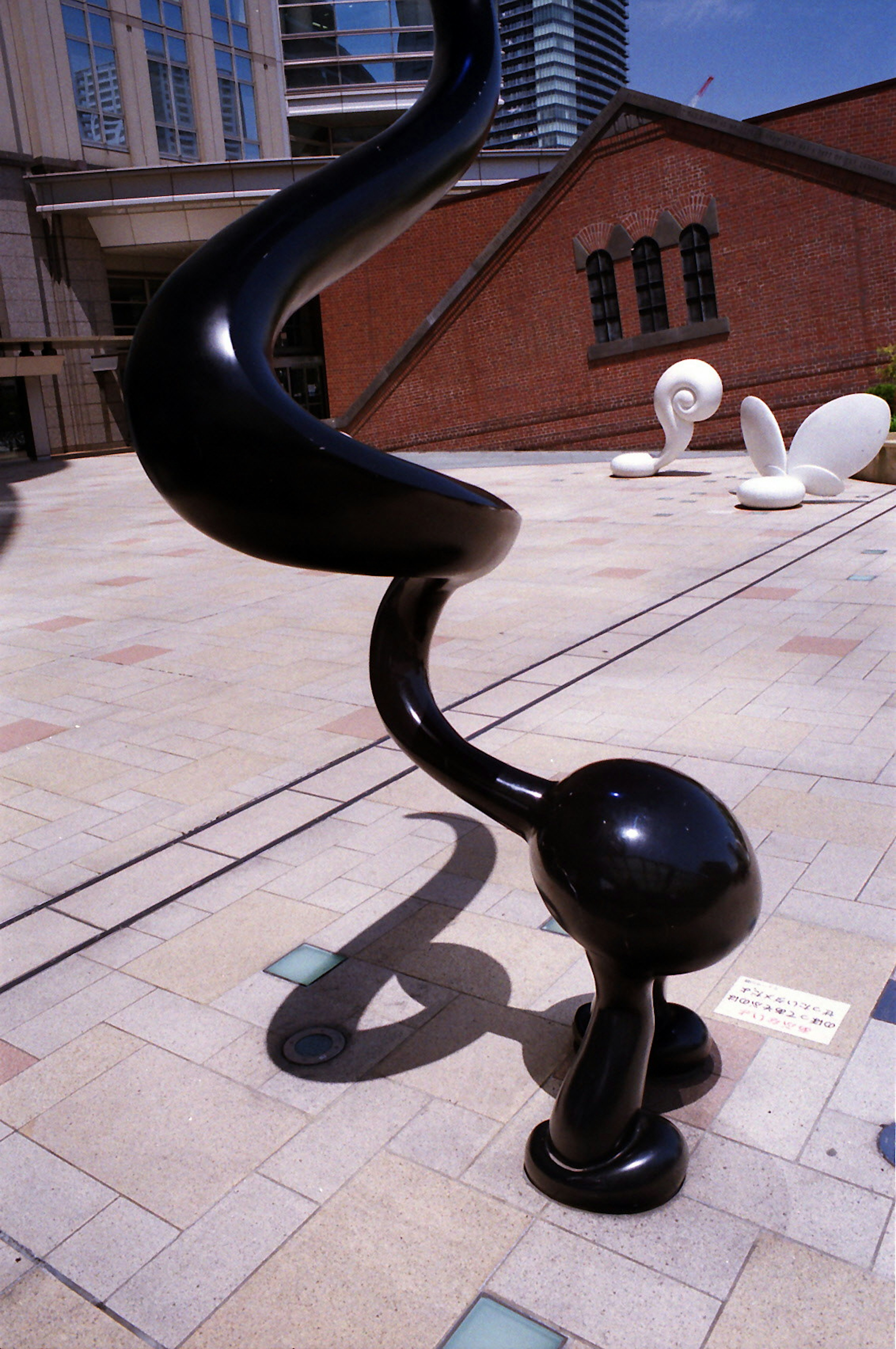 Outdoor art space featuring a distinctive black sculpture