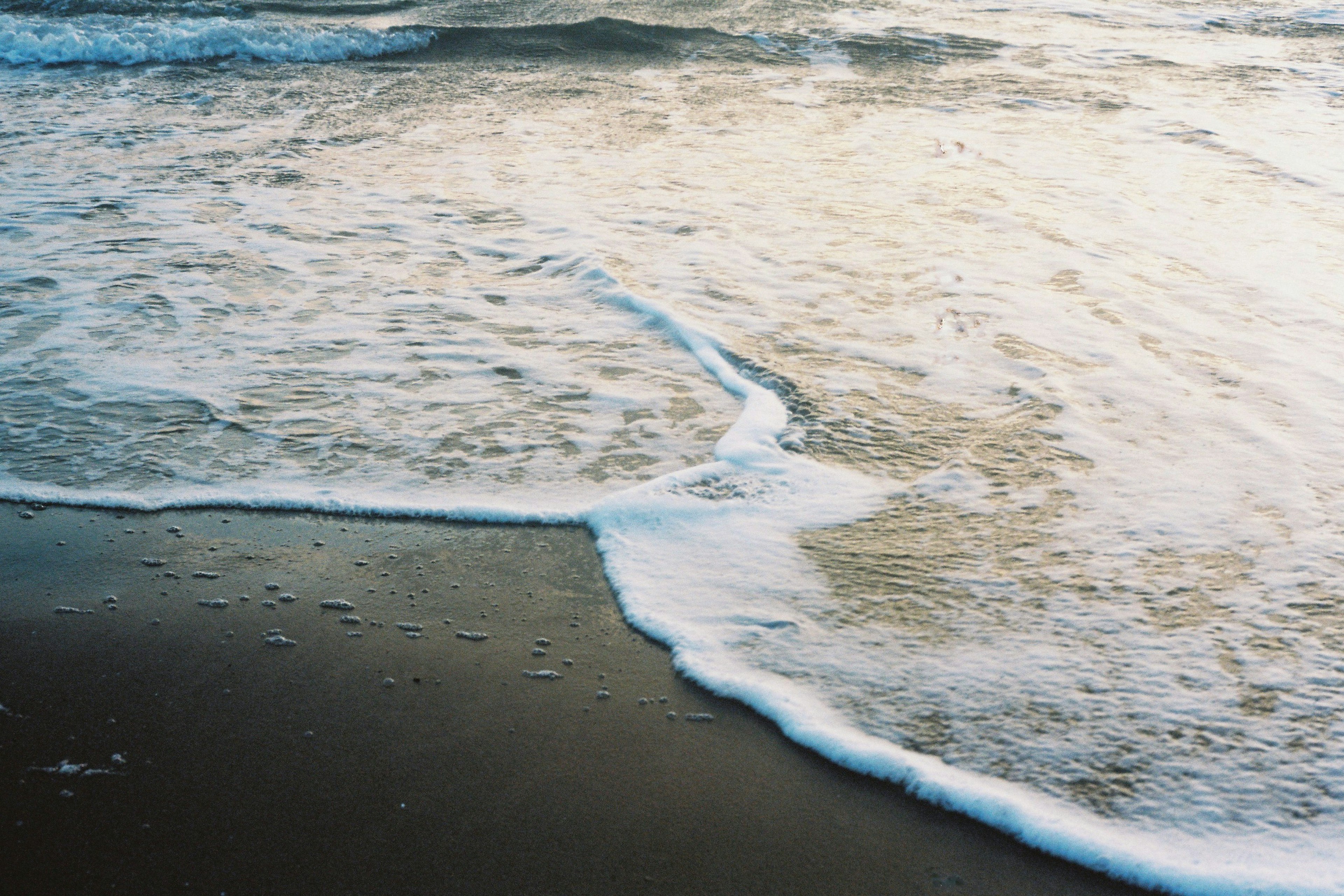 穏やかな波が砂浜に寄せる海の風景