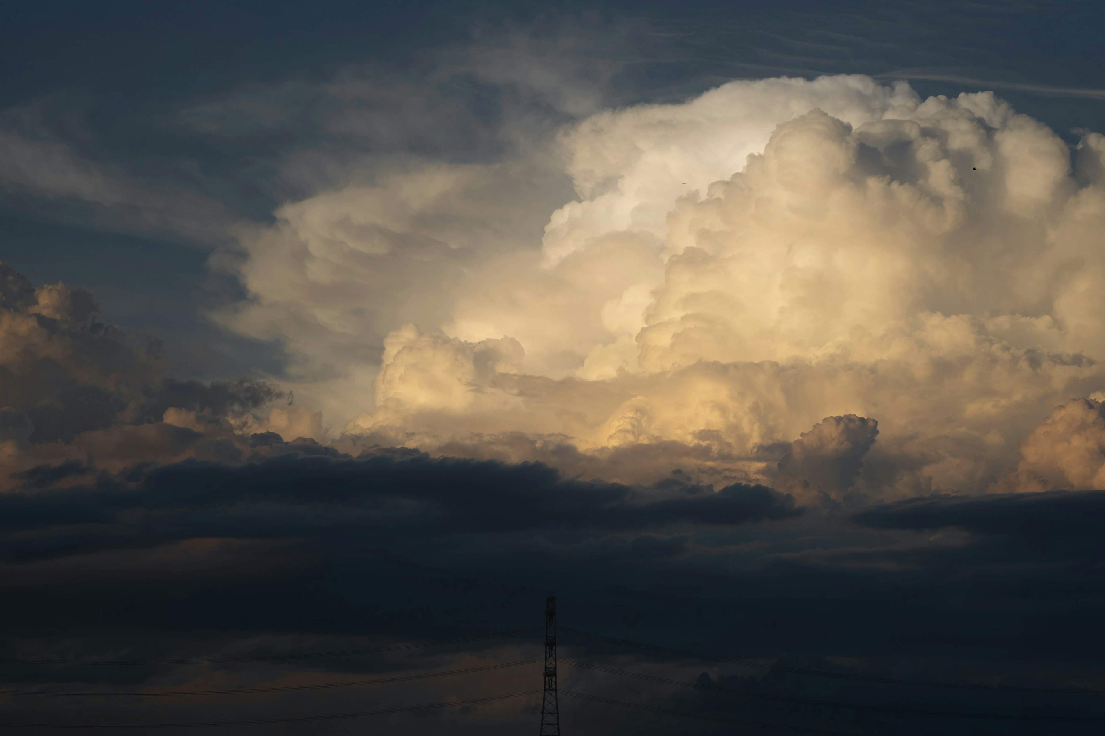 Large clouds illuminated by light against a dark sky