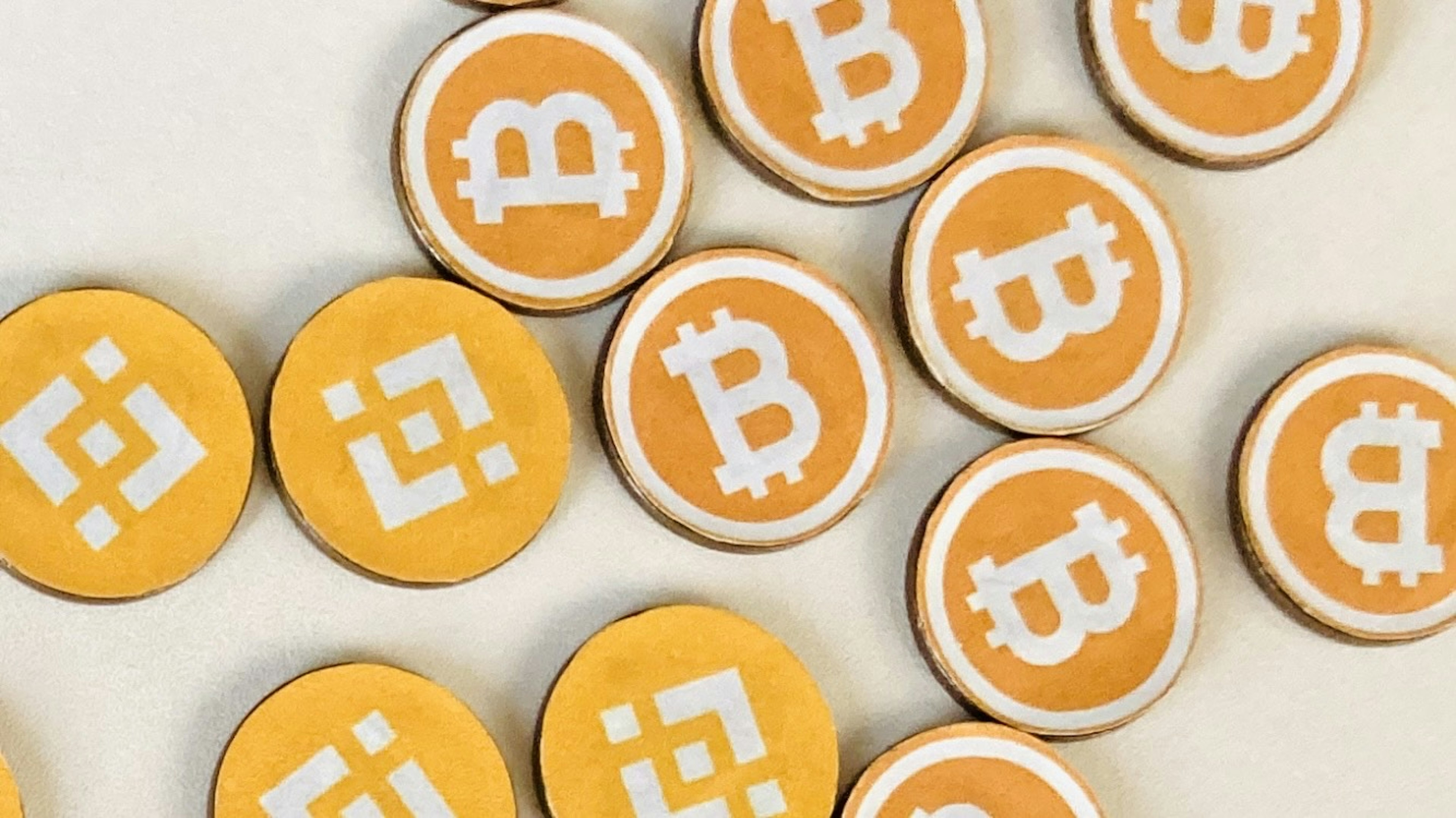 Coins featuring Bitcoin and Binance logos scattered on a surface