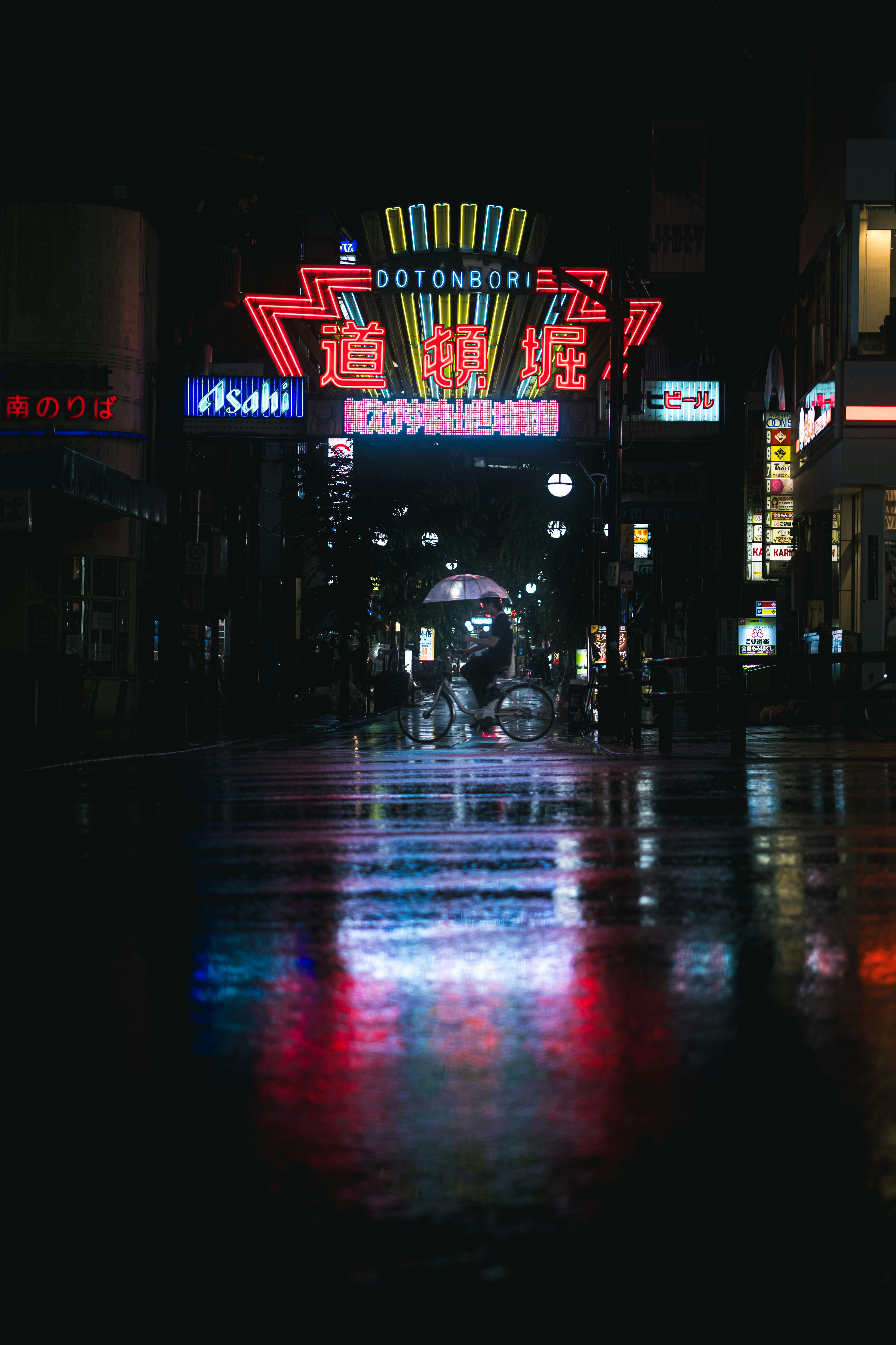 雨水浸濕的城市街道上的霓虹燈和倒影