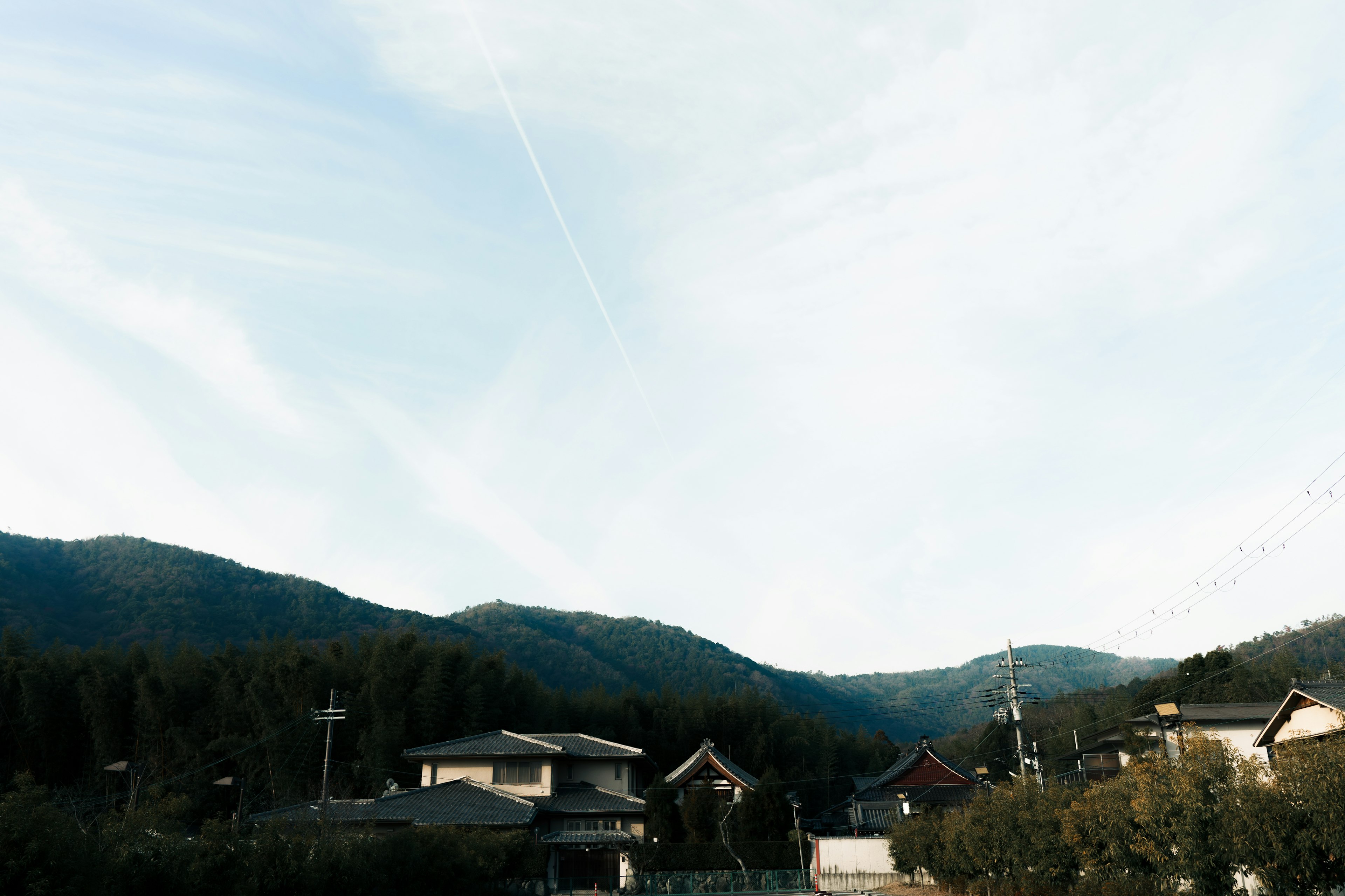 Japanische Häuser umgeben von Bergen unter einem blauen Himmel