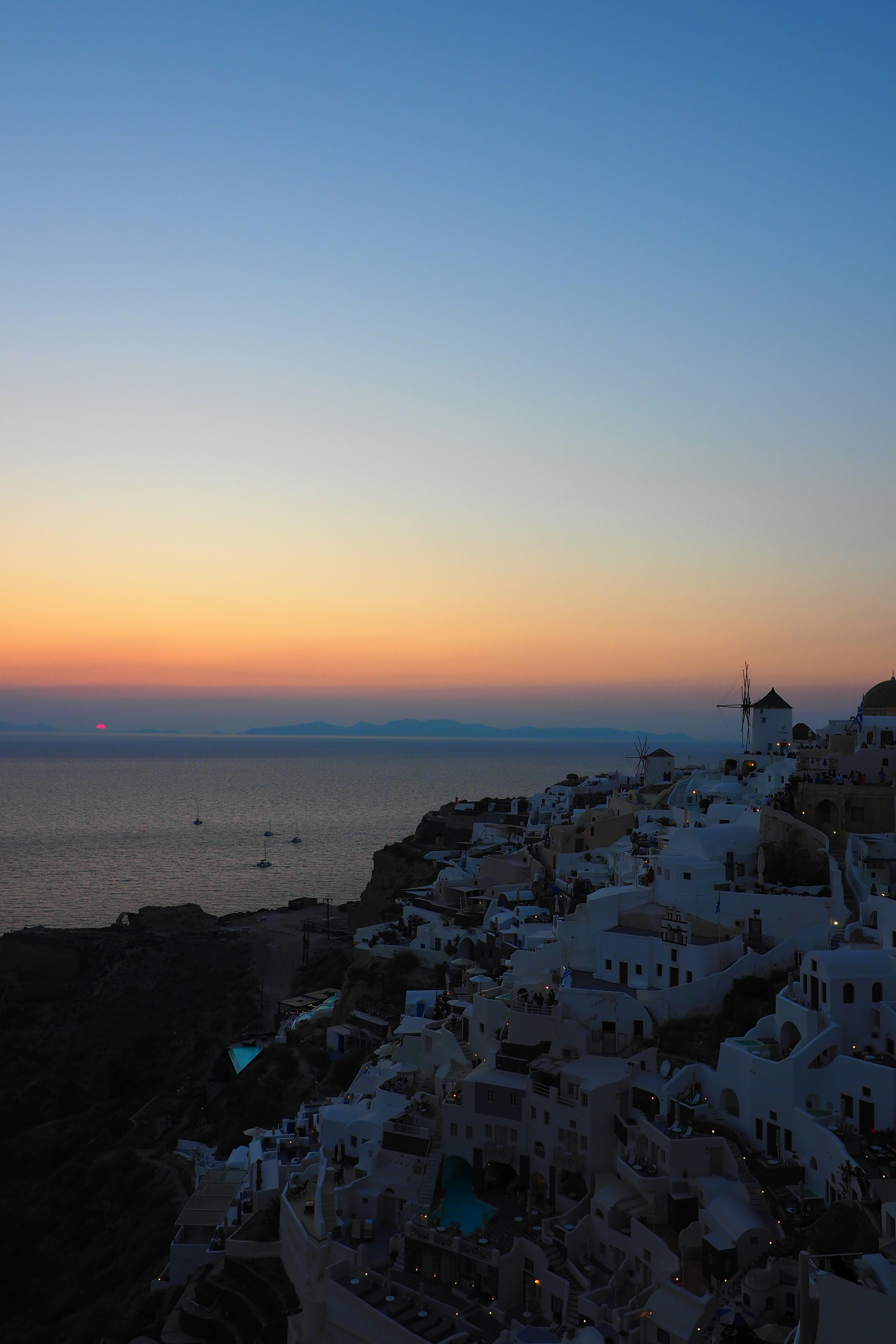 Coucher de soleil à Santorin avec des bâtiments blancs et vue sur la mer