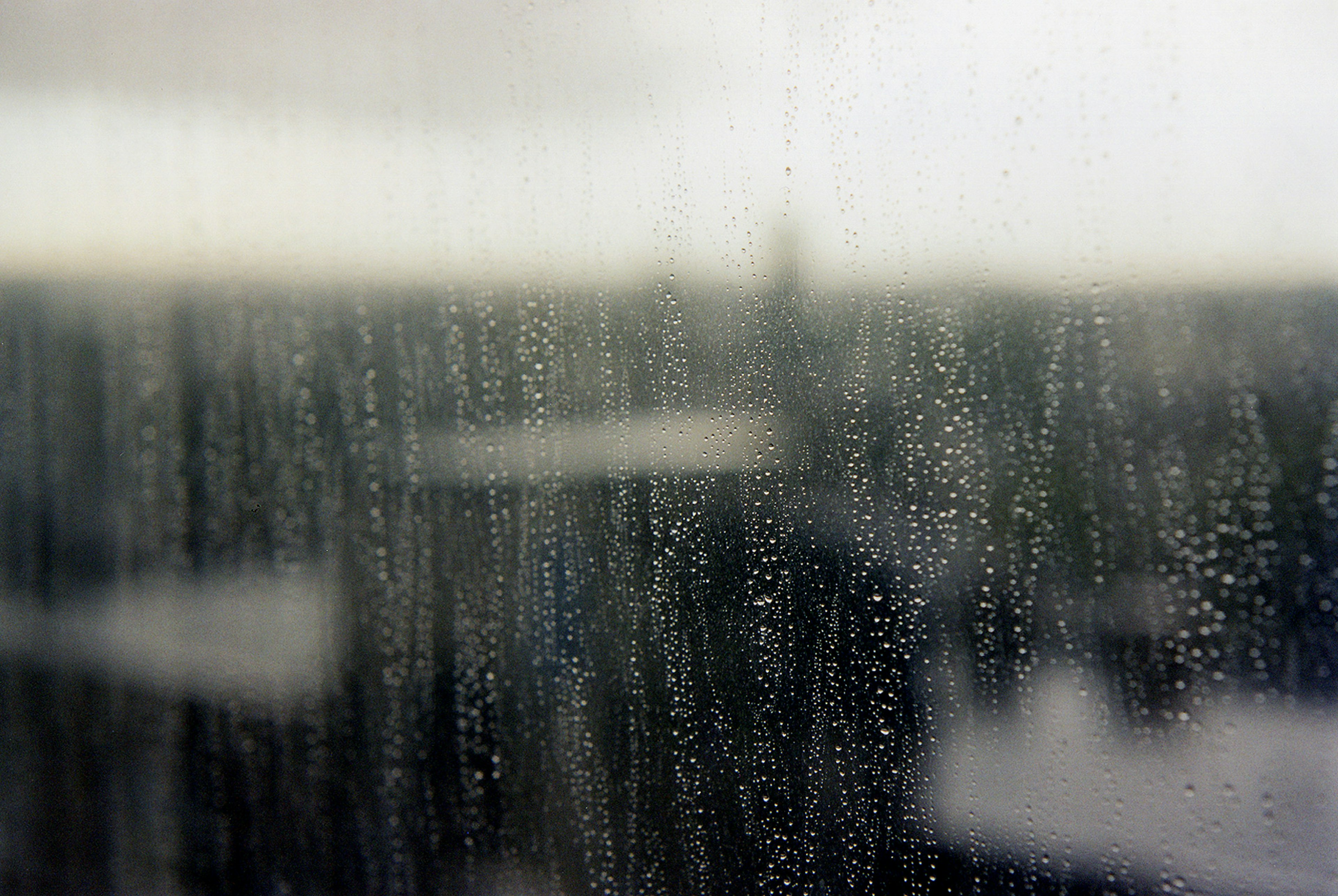 Blurred view through a rain-soaked window