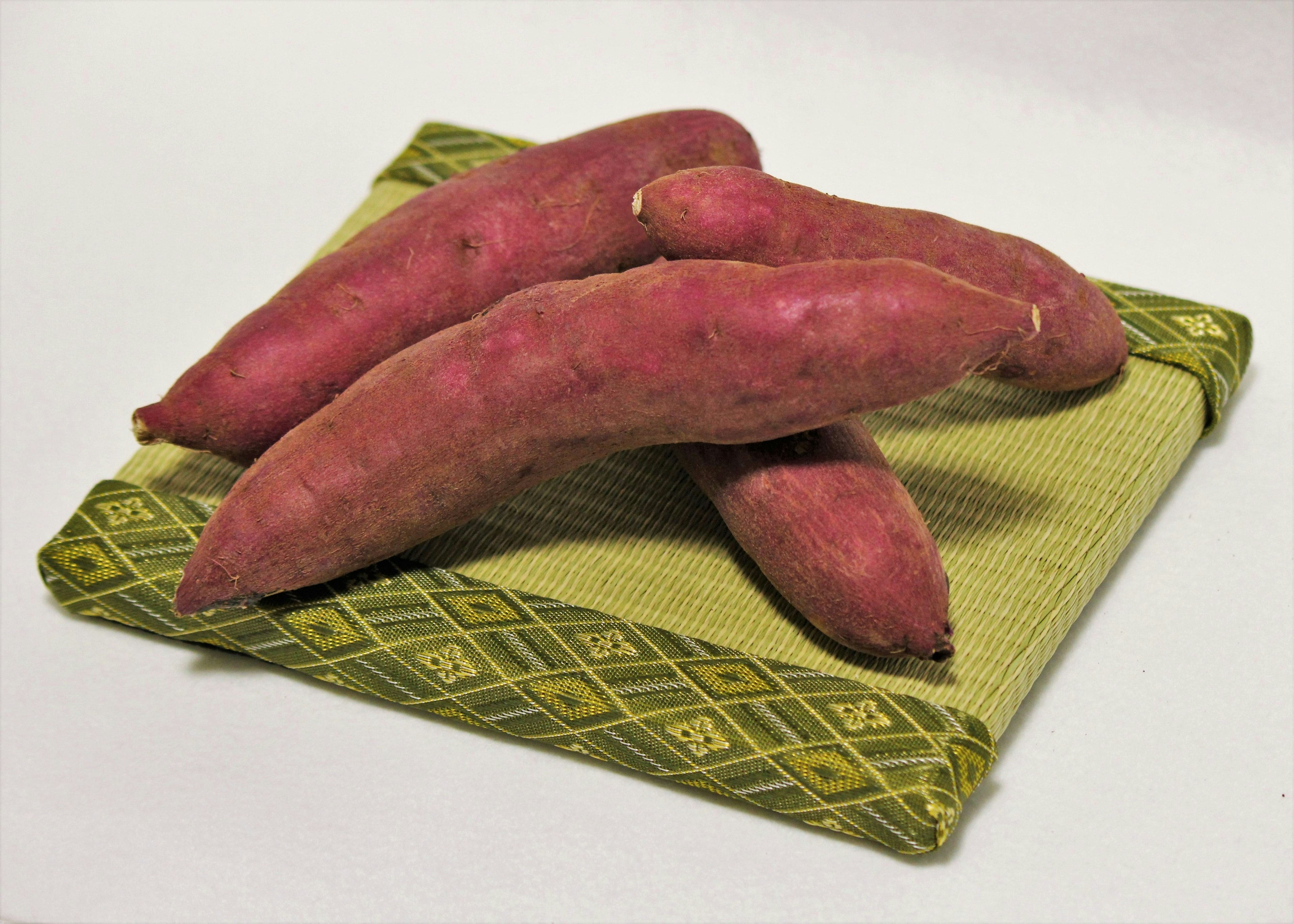 Purple sweet potatoes placed on a green cloth