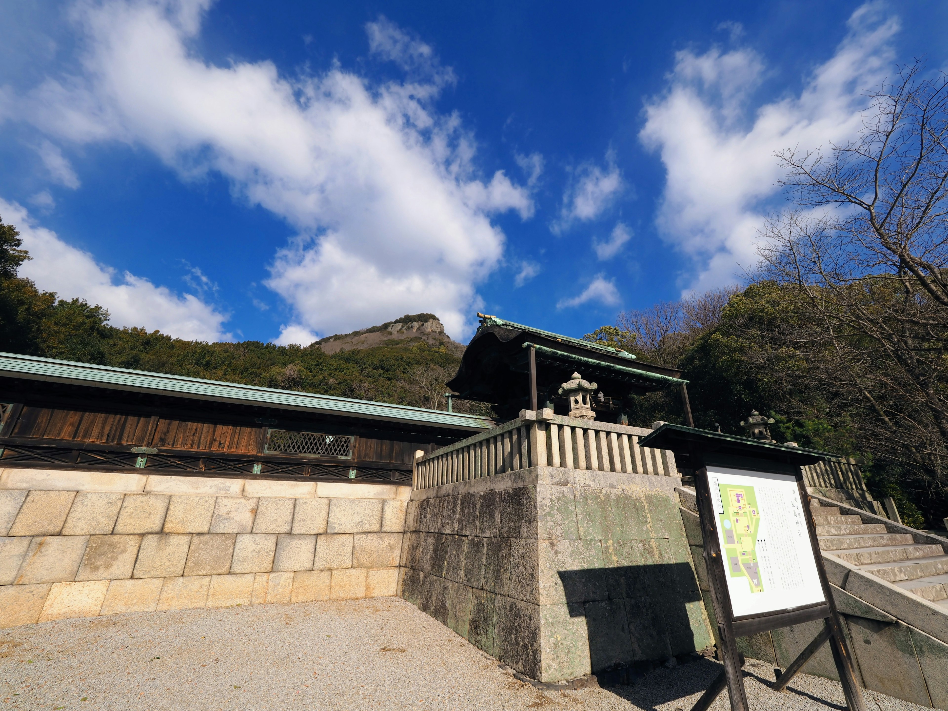 Une vue pittoresque avec un bâtiment en pierre et un panneau sous un ciel bleu