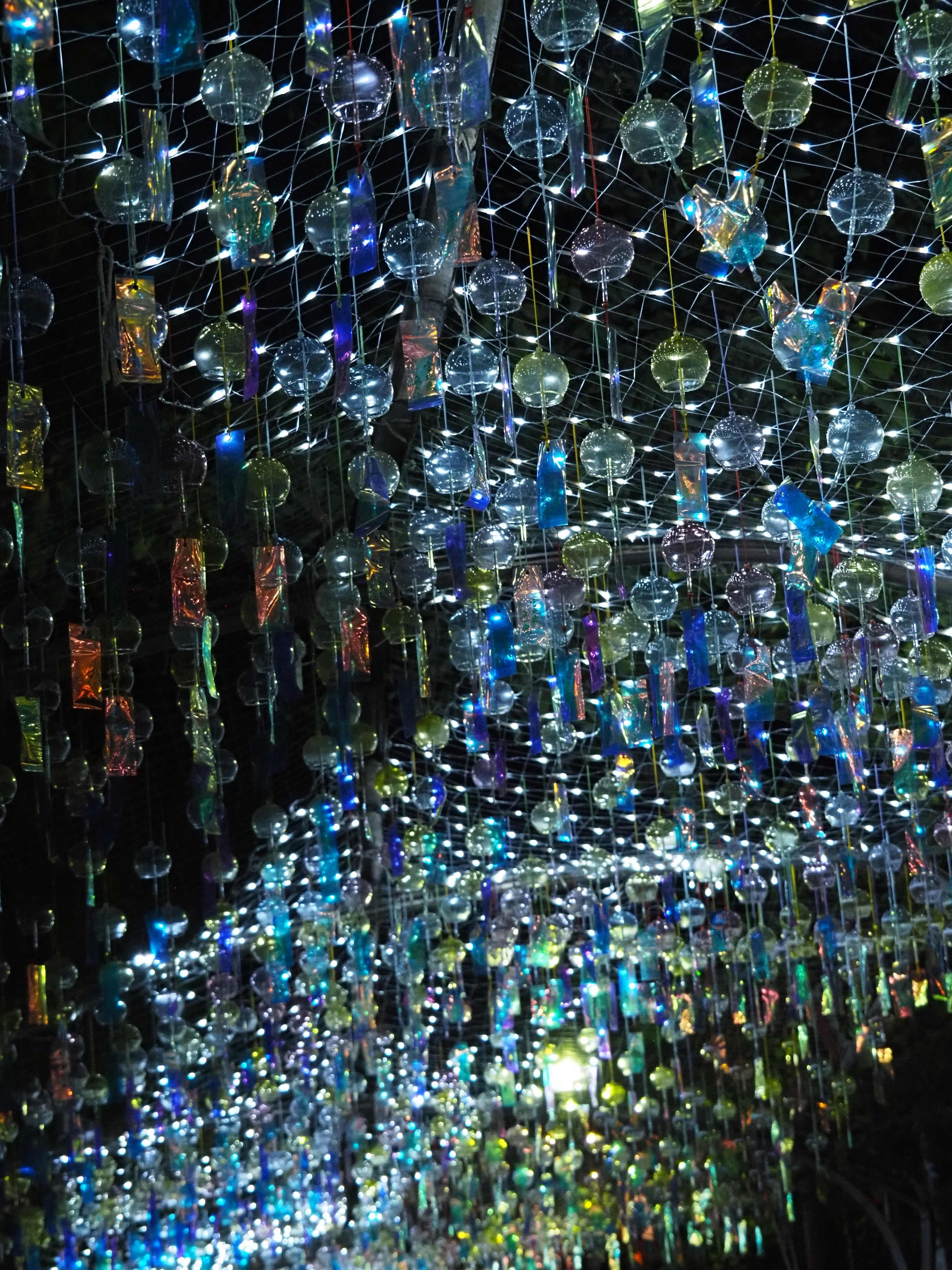 A whimsical ceiling decoration featuring colorful glass orbs hanging from strings