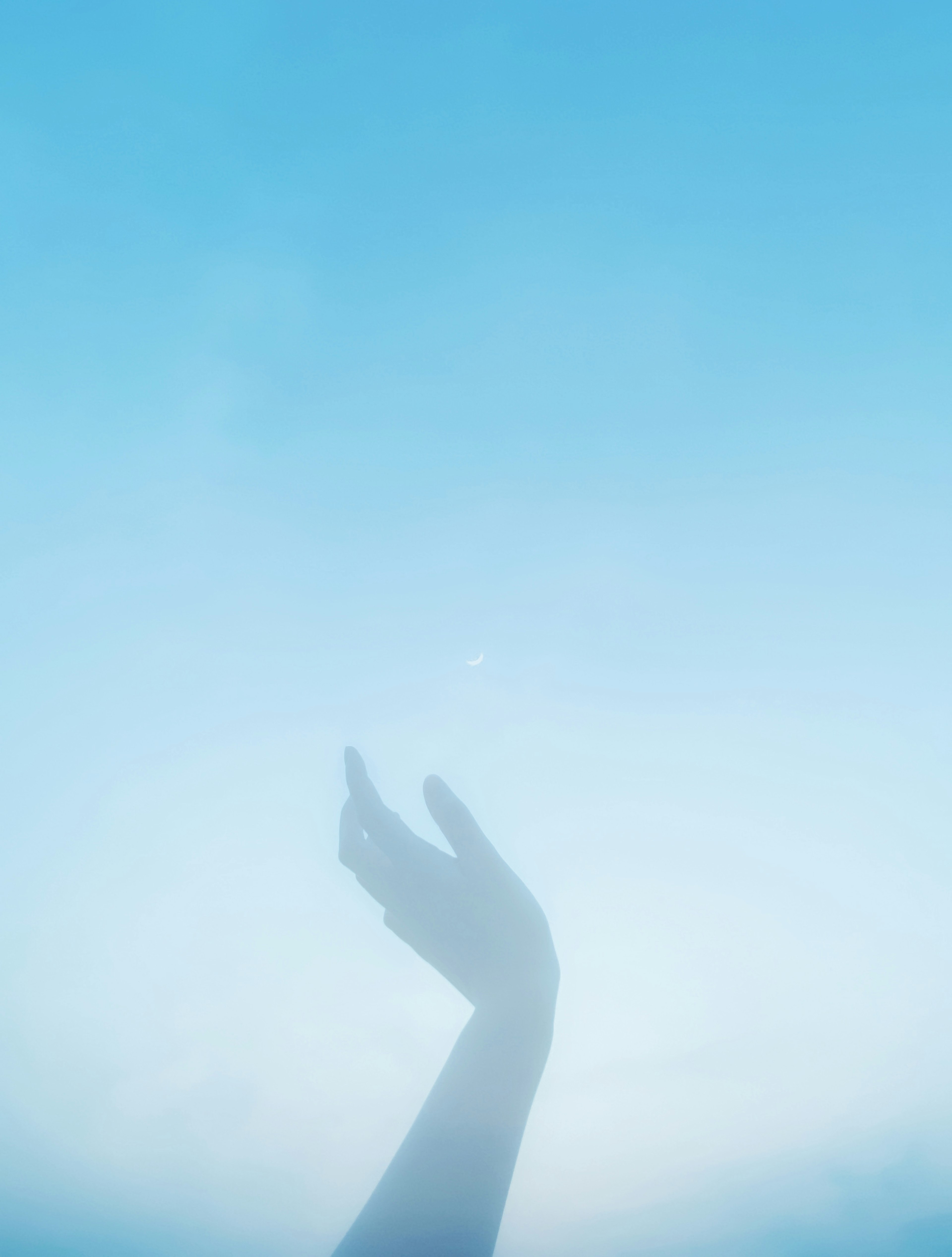 Silhouette of a hand against a blue sky